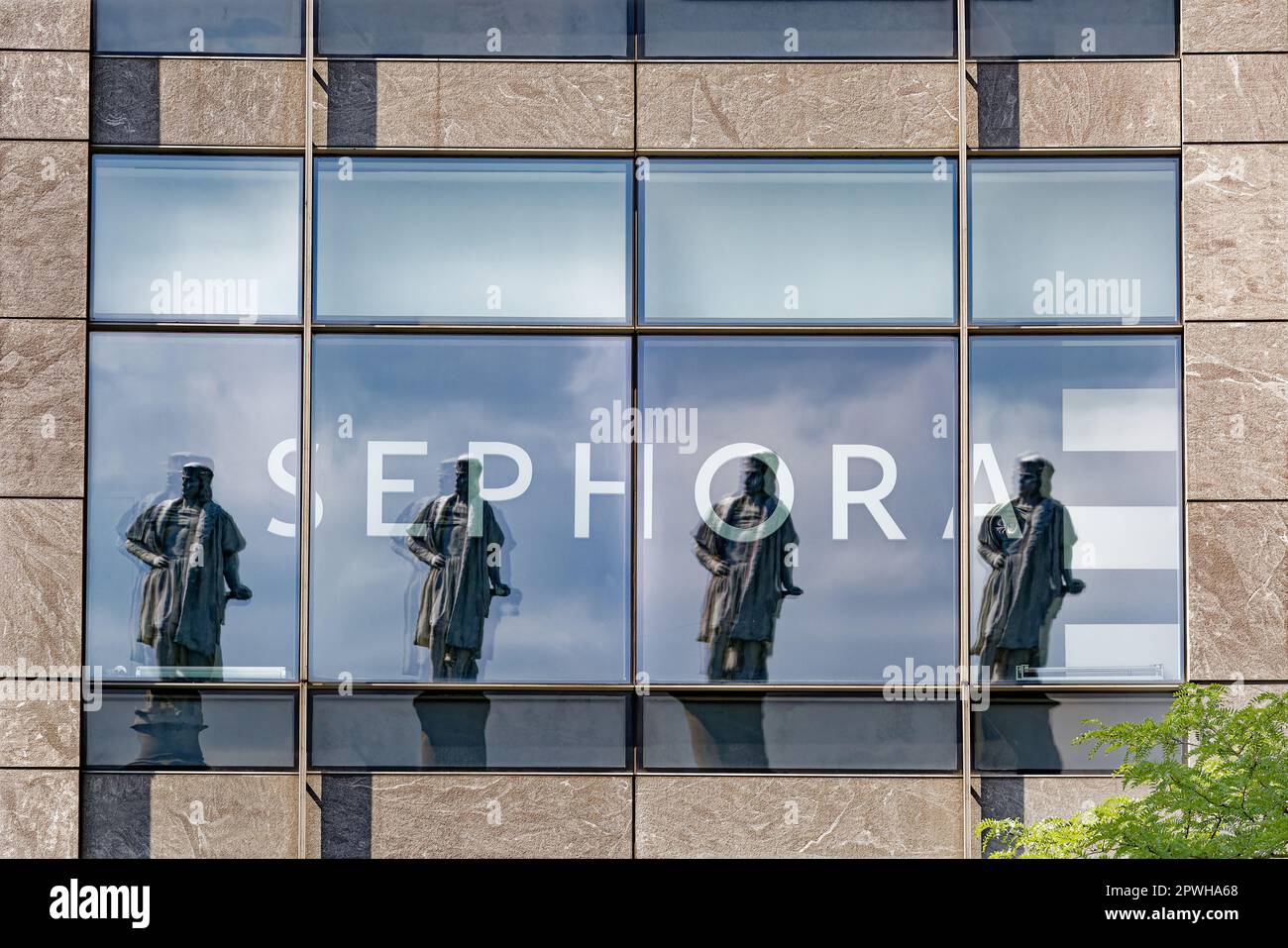 Sephoras Fenster im dritten Stock in der geschwungenen Fassade am Columbus Circle 10 spiegeln die Christoph Columbus Statue viermal wider. Stockfoto