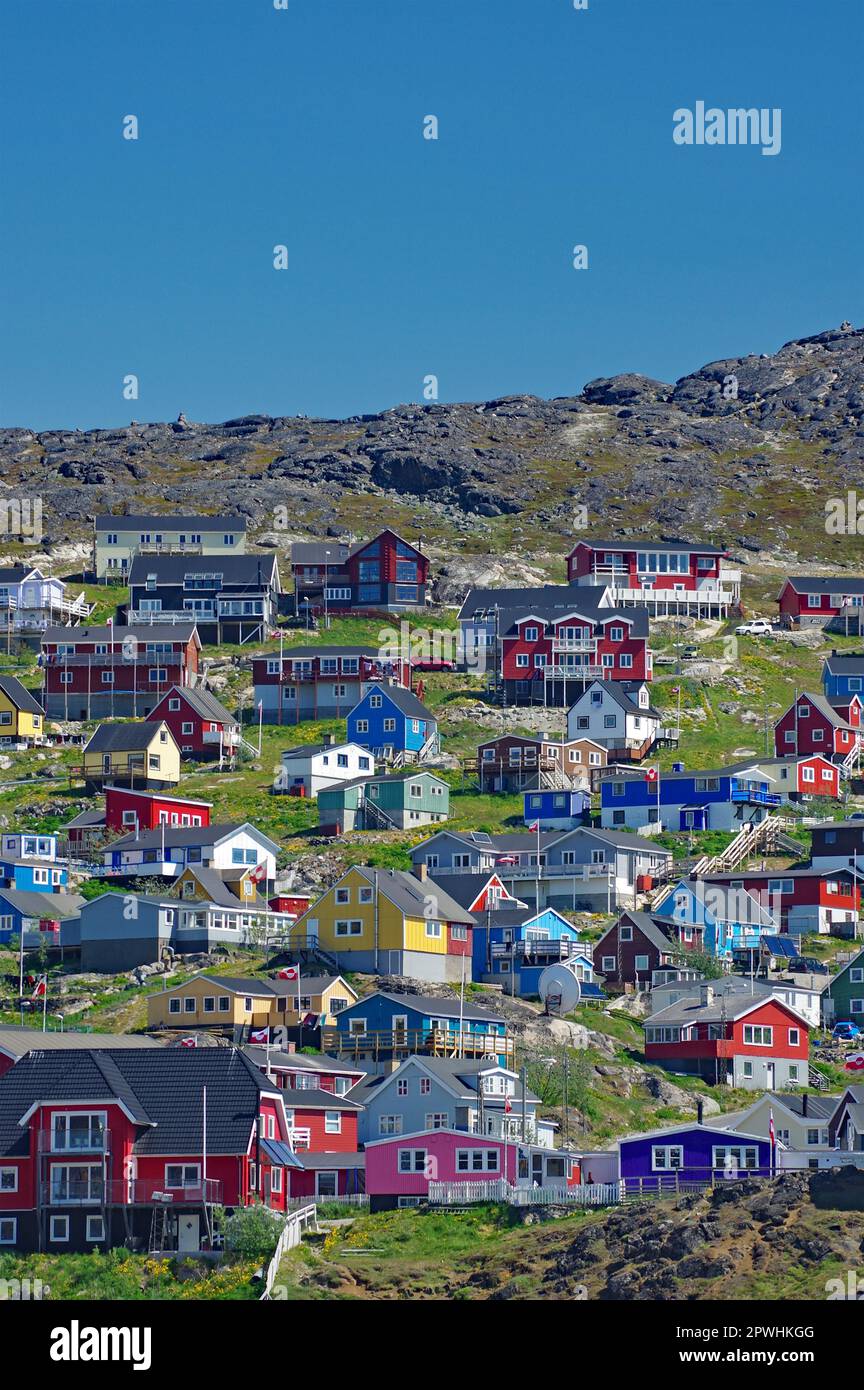 Blick über eine kleine Stadt mit Holzhäusern in verschiedenen Farben, zerklüftete Berglandschaft, Qaqortoq, Kujalleq Municipality, Arctic, Grönland, Dänemark Stockfoto