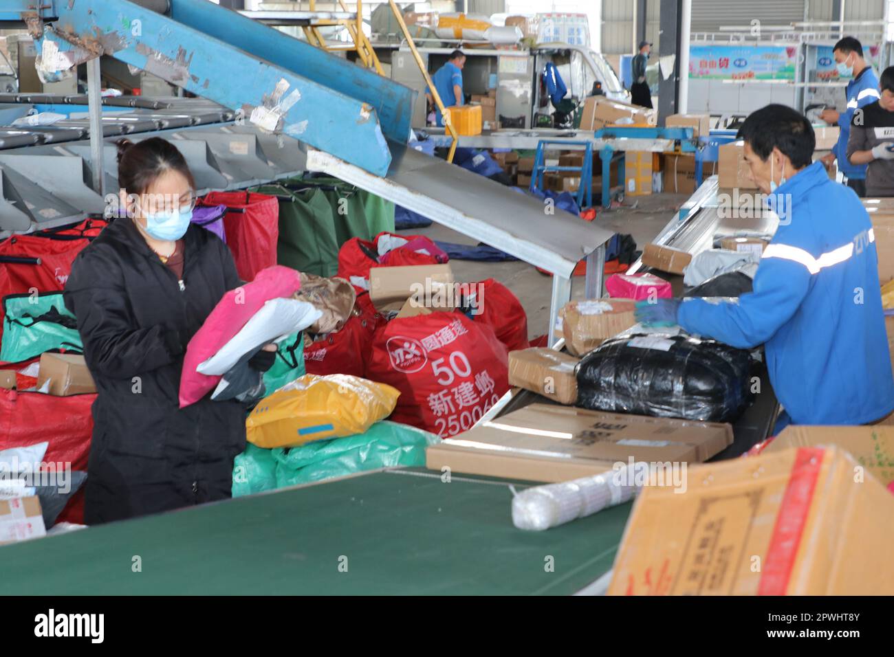 LIANYUNGANG, CHINA - 1. MAI 2023 - Mitarbeiter der Zto Express Company sortieren Lieferungen an ihrem Arbeitsplatz in Lianyungang City, Ostchina Jiangsu Way Stockfoto