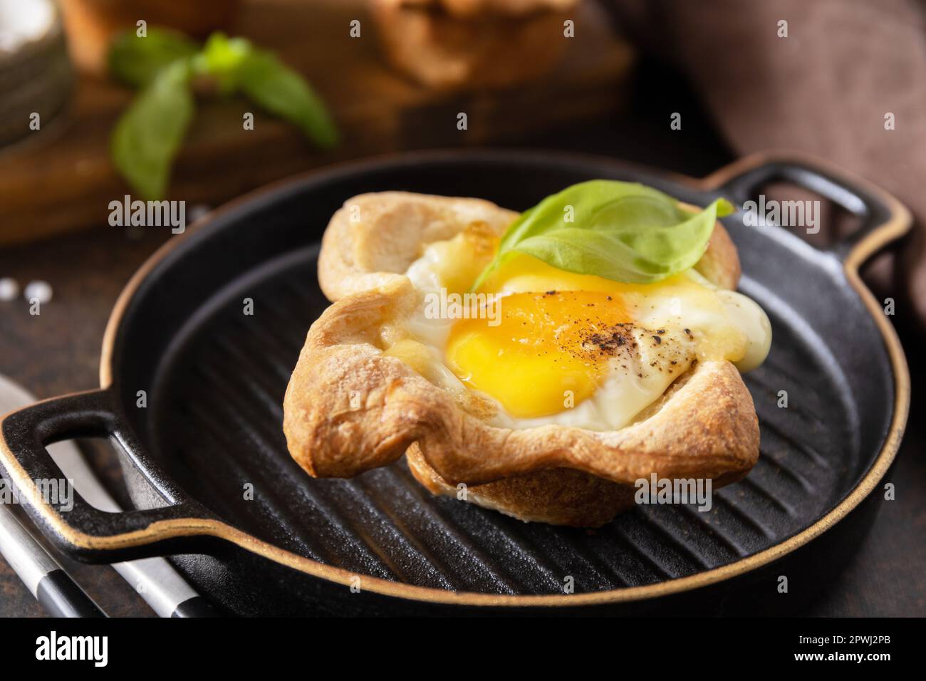 Rührei in Blätterteig mit Käse und Speck auf einem Steinteller. Frühstücksidee, Snacks. Stockfoto