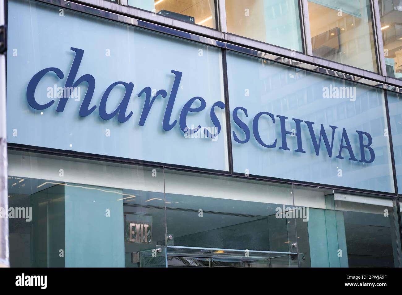 New York, NY - 26. April 2023 - Charles Schwab Corporation Financial Services Company Logo im Fenster der Zweigstelle Midtown Manhattan Stockfoto