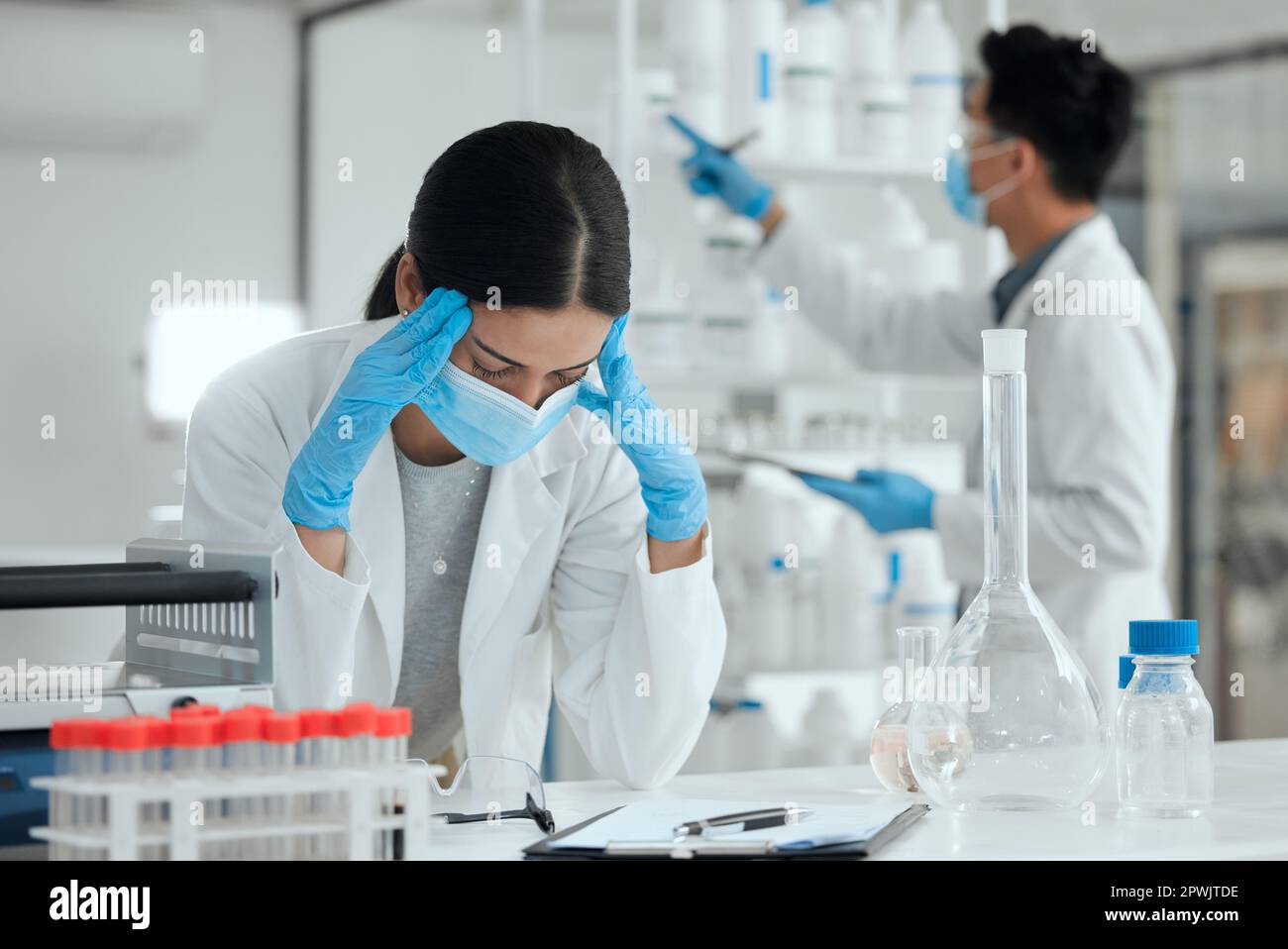 Wenn Experimente schief gehen. Eine junge Wissenschaftlerin, die gestresst und Kopfschmerzen hat Stockfoto