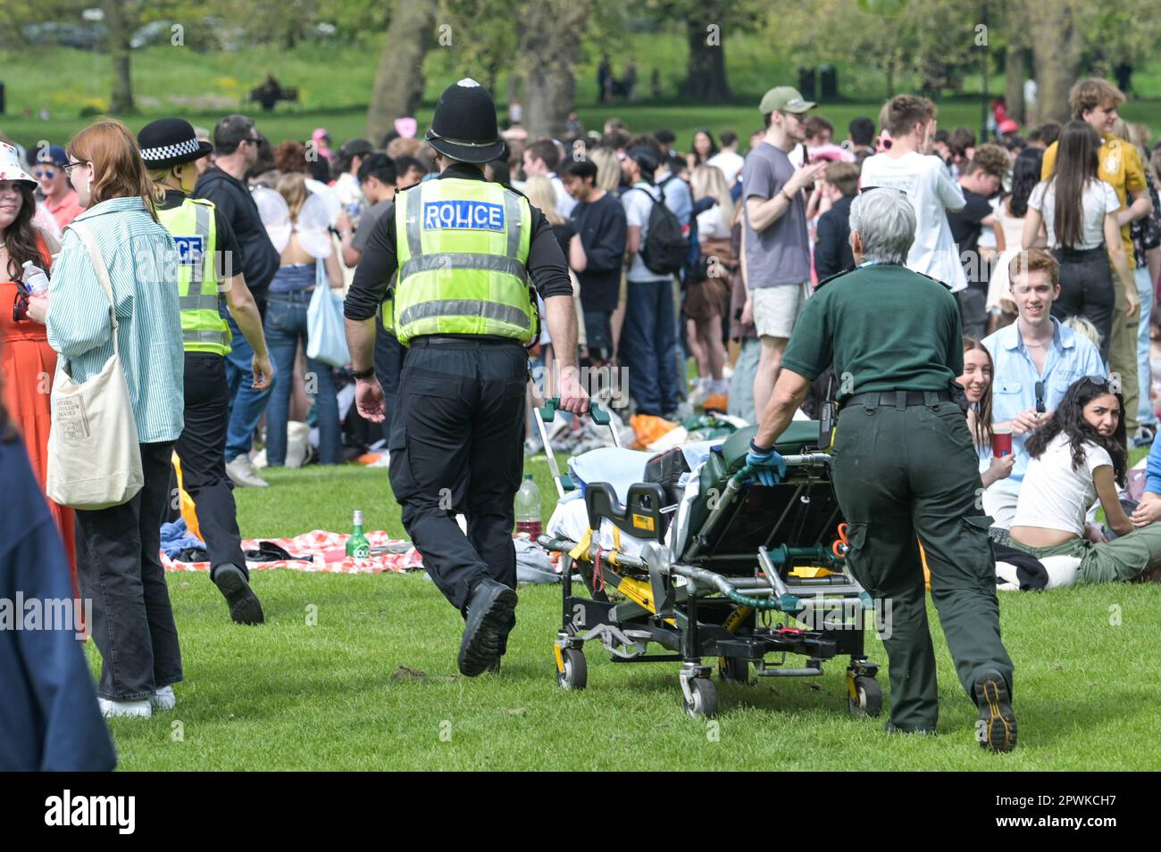 Jesus Green, Cambridge, 30. April 2023 - der Rettungsdienst kümmerte sich um diejenigen, die etwas zu hart gefeiert hatten. - Horden von Studenten der Universität Cambridge strömten am Sonntagnachmittag in den Park, um die jährliche "Caesarian Sunday"-Trinkparty zu veranstalten. Studenten der angesehenen Institution haben den Nachmittag in schicken Kleidern durchgemacht und an Trinkspielen auf Jesus Green teilgenommen. Die Tradition, auch bekannt als „C-Sonntag“, zieht Tausende von Studenten an, kurz bevor sie an Prüfungen teilnehmen. Die Polizei war anwesend, um die Akademiker in Schach zu halten. Quelle: St Stockfoto