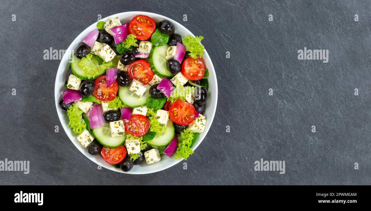 Griechischer Salat mit frischen Tomaten, Oliven und Fetakäse gesunde Lebensmittel von oben auf einem Schieferbanner mit Kopierraum essen Stockfoto