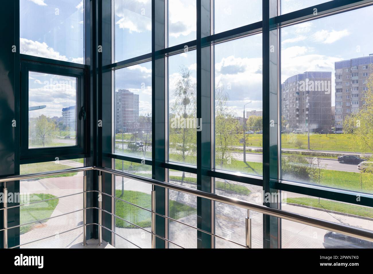 Blick auf die Straße an einem sonnigen Sommertag von der Treppe aus mit Panoramafenster. Ein Element moderner Architektur. Stockfoto