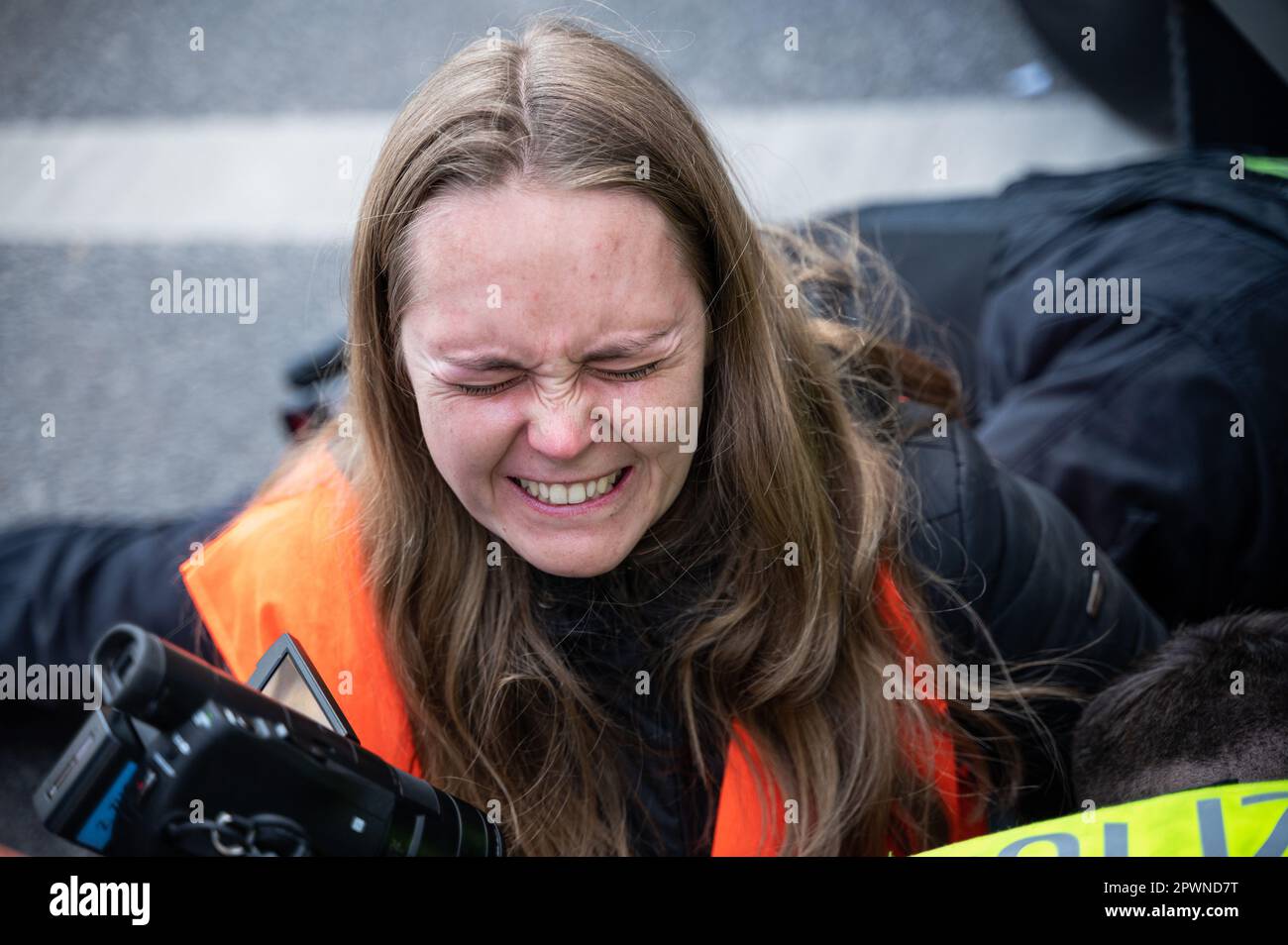 28.04.2023, Berlin, Deutschland, Europa - mit Speiseöl lockern Polizeibeamte die Hand von Klimaprotestierenden der letzten Generation. Stockfoto