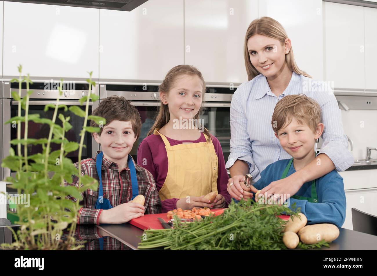 Schüler und Lehrerin, die Kartoffeln mit Kartoffelschäler schälen, in der Hauswirtschaftsschule, Bayern, Deutschland Stockfoto