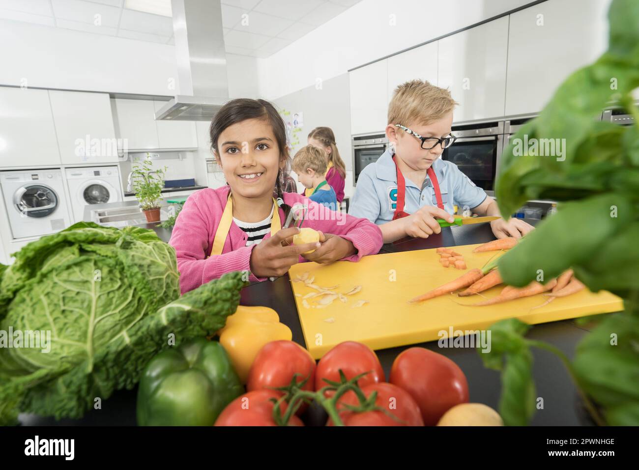 Schüler, die Gemüse schälen und schneiden in der Hauswirtschaftsschule, Bayern Stockfoto
