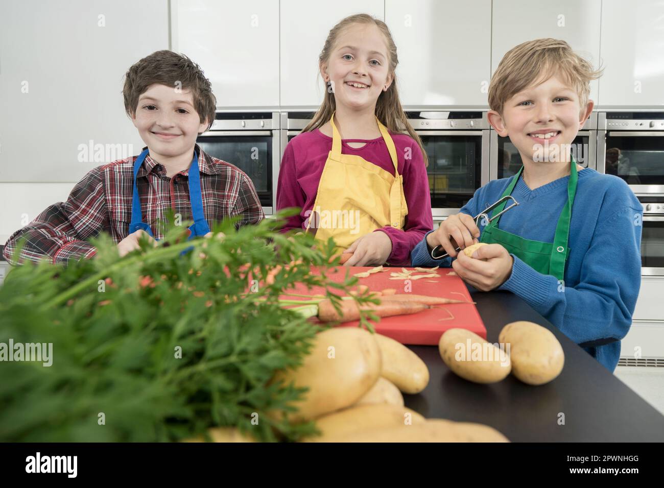 Schüler, die Gemüse schälen und schneiden in der Hauswirtschaftsschule, Bayern Stockfoto