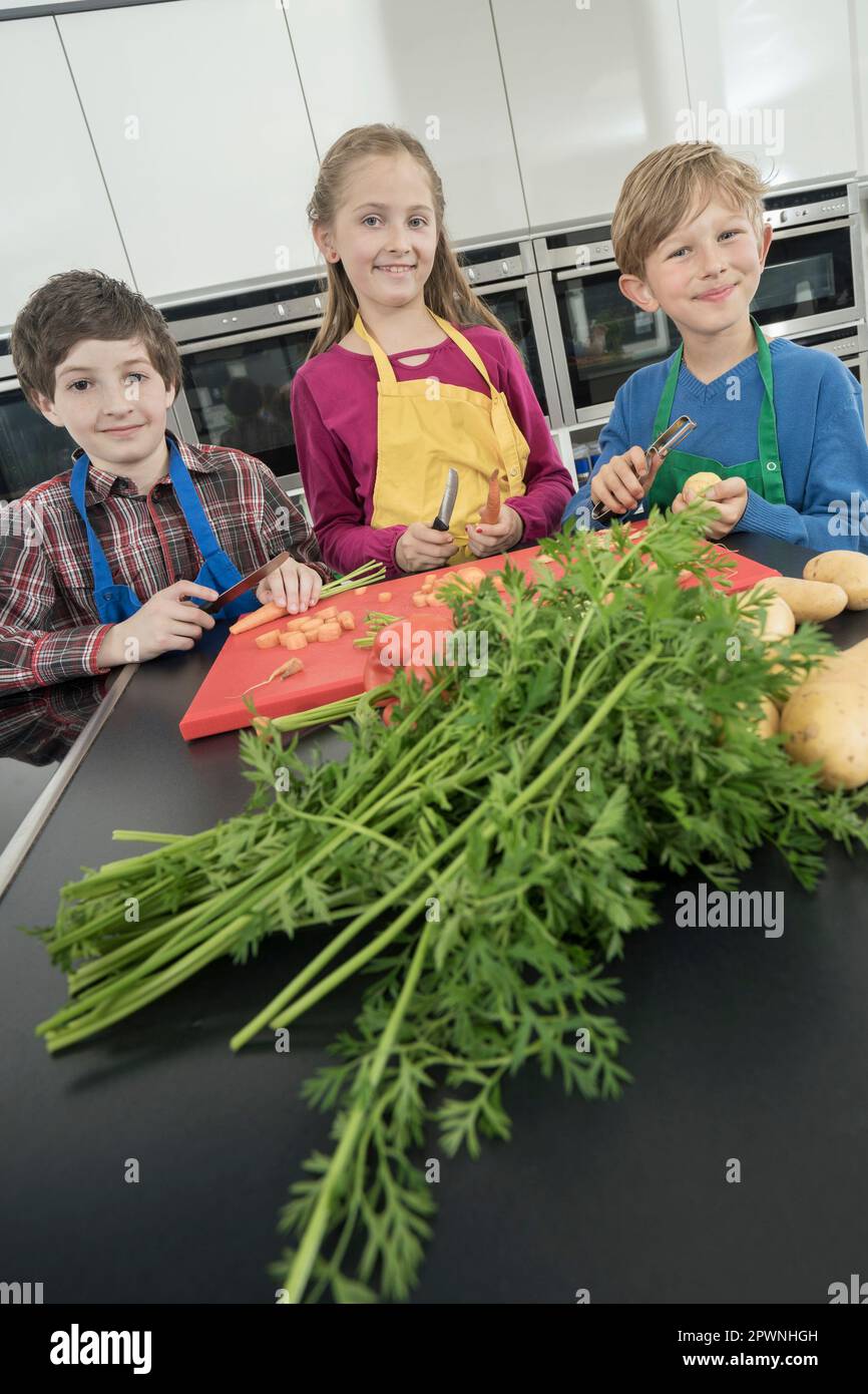 Schüler, die Gemüse schälen und schneiden in der Hauswirtschaftsschule, Bayern Stockfoto