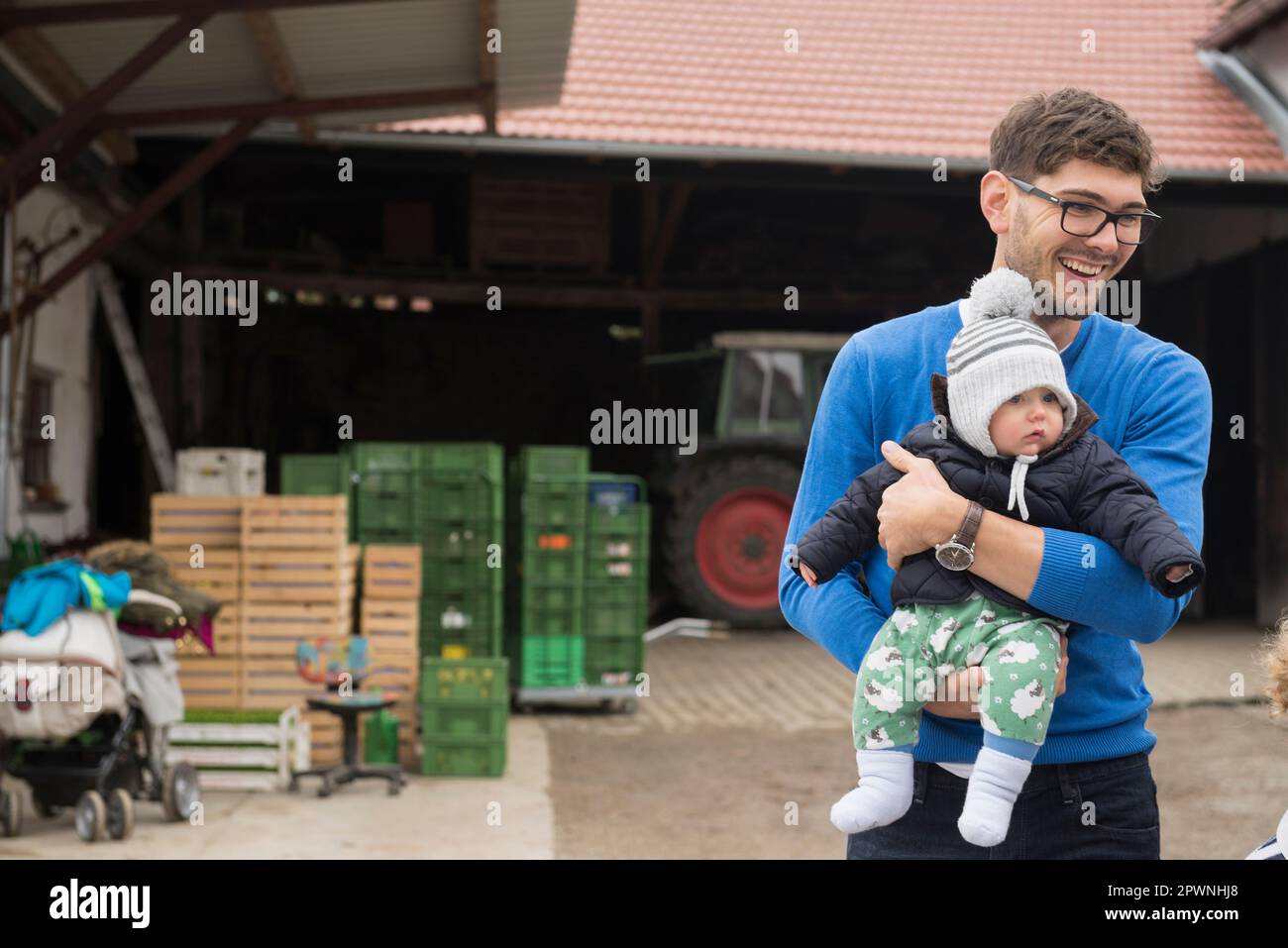 Ein erwachsener Mann, der seinen Sohn trägt und lächelt, Bayern, Deutschland Stockfoto