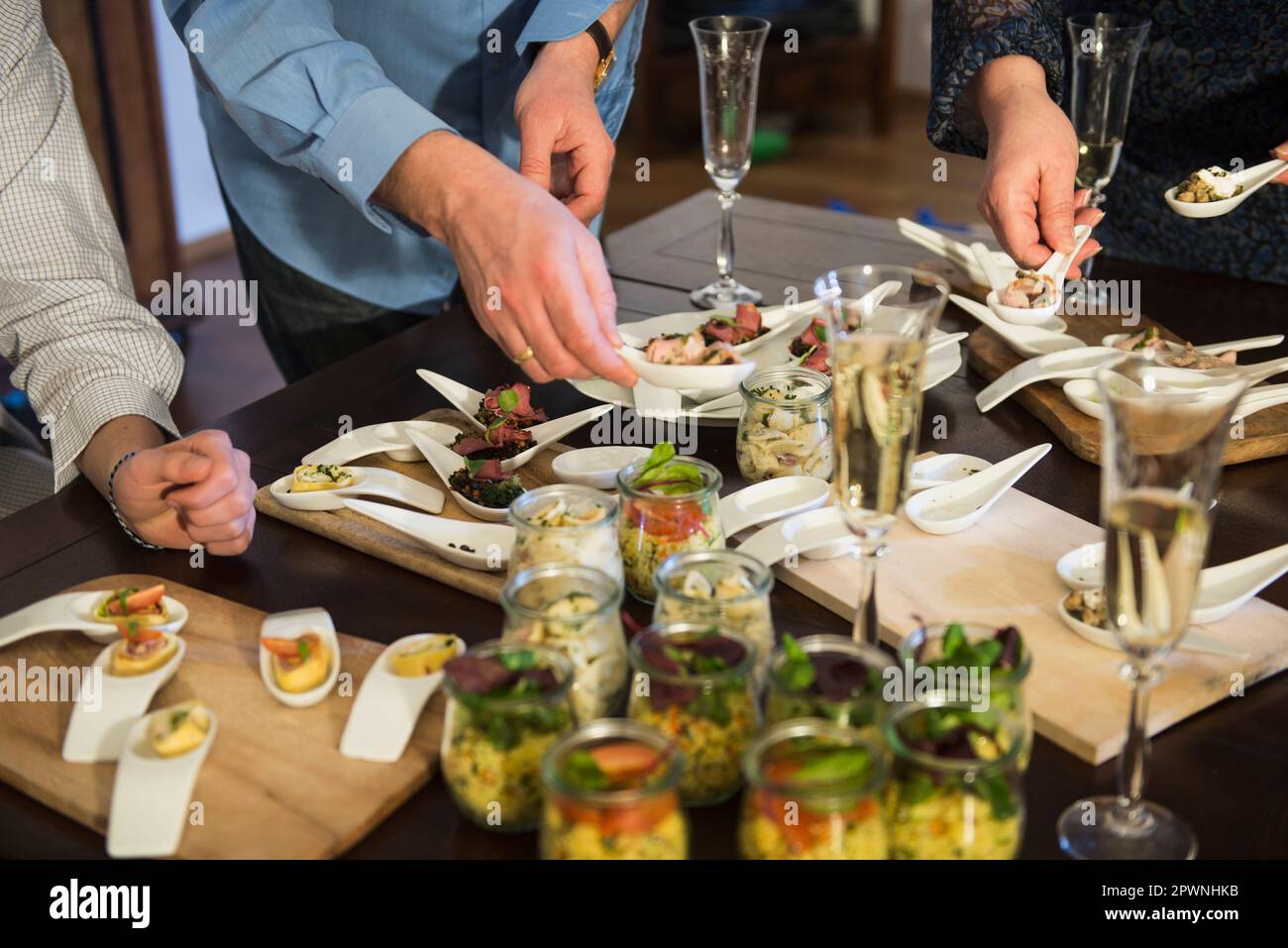 Partygäste helfen sich am Buffet Stockfoto