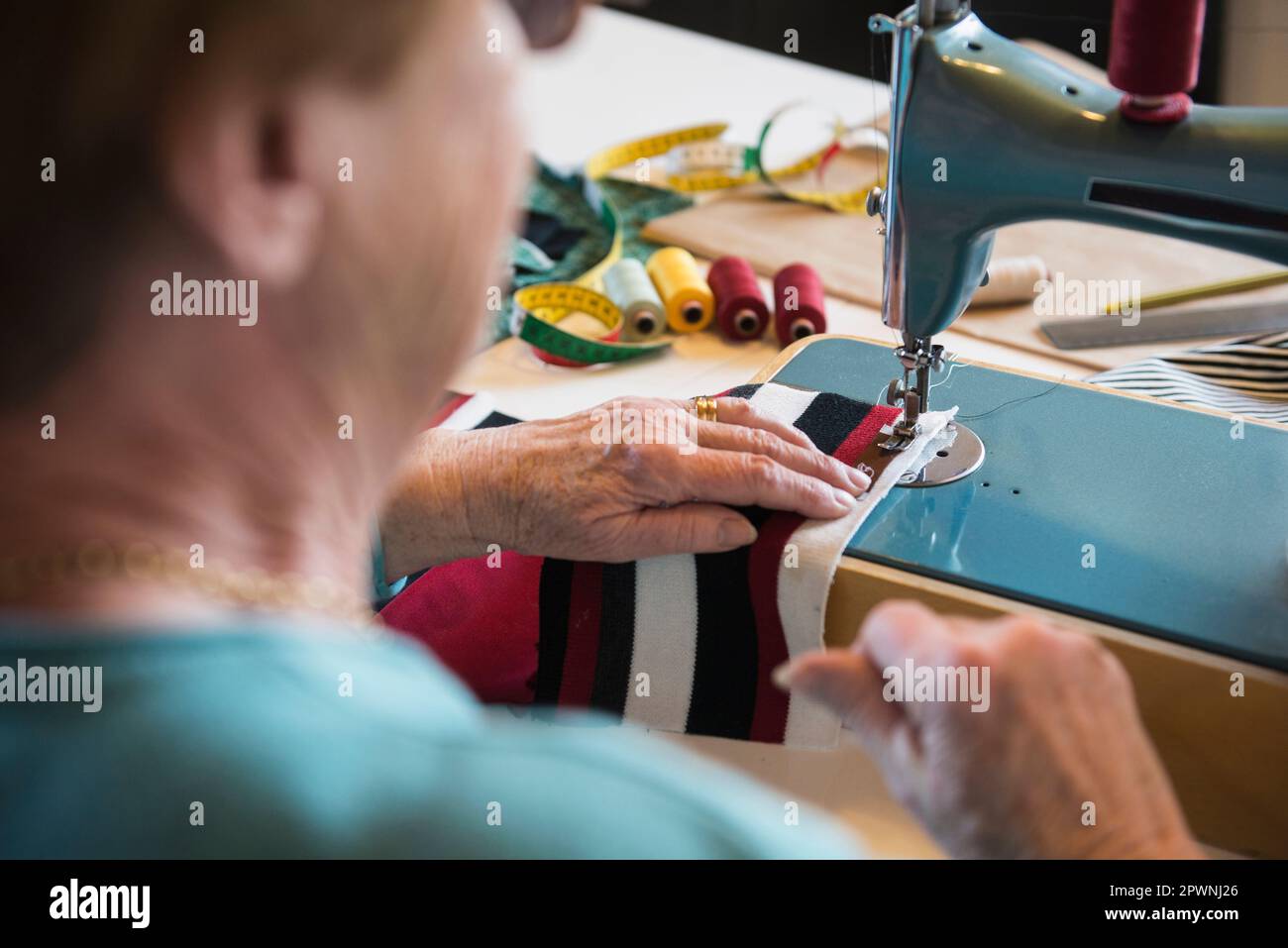 Alte Frau, die an der Nähmaschine arbeitet Stockfoto