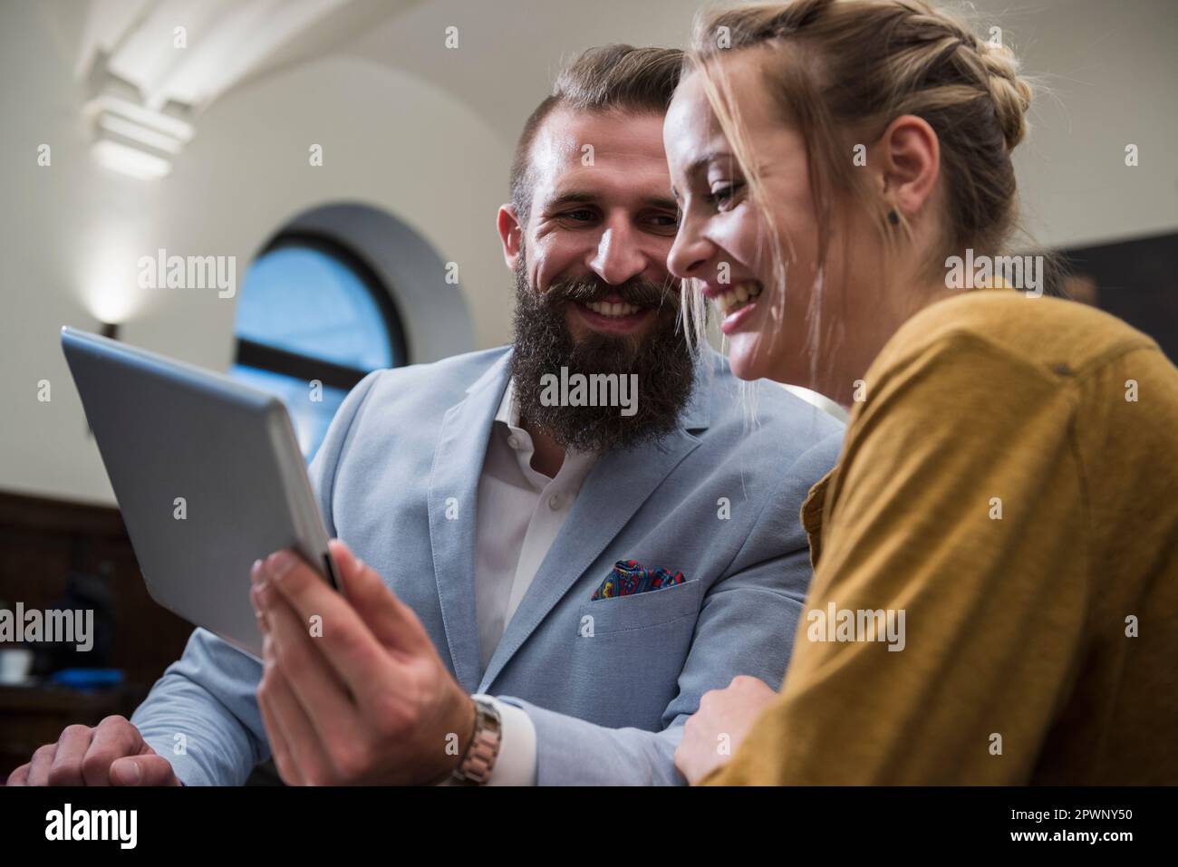 Fröhliches Paar, das beim Verwenden eines digitalen Tablets im Restaurant lächelt Stockfoto