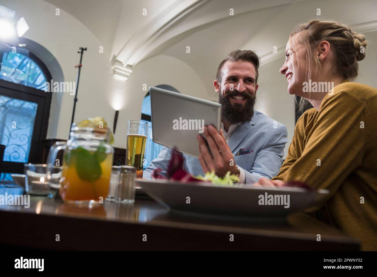 Lächelndes Paar mit einem digitalen Tablet im Restaurant Stockfoto