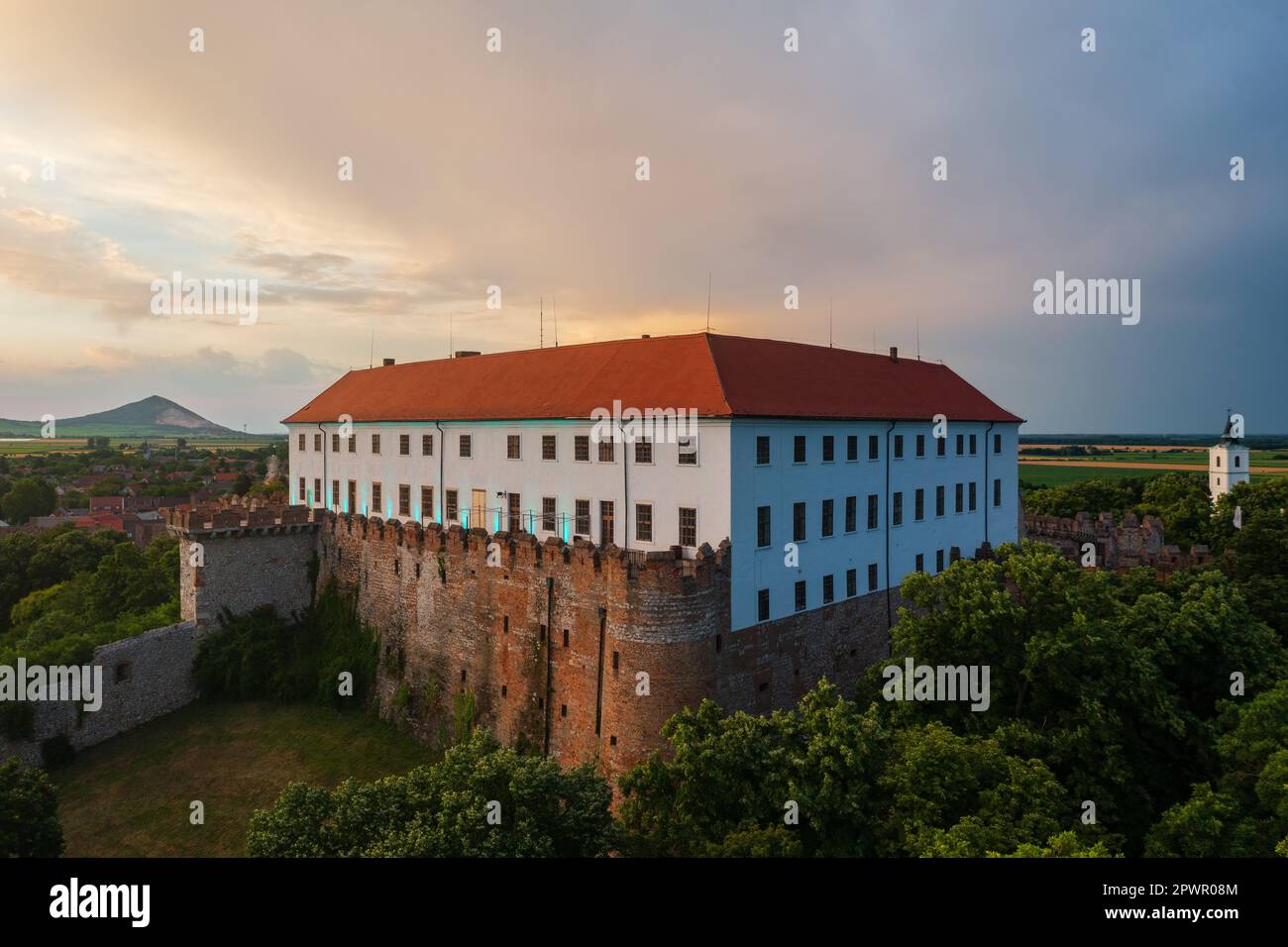 Aus der Vogelperspektive auf die Burg Siklós, die sich am südlichen Fuß des Villány-Gebirges befindet. Spektakulärer Sonnenaufgang im Sommer im Hintergrund. Stockfoto