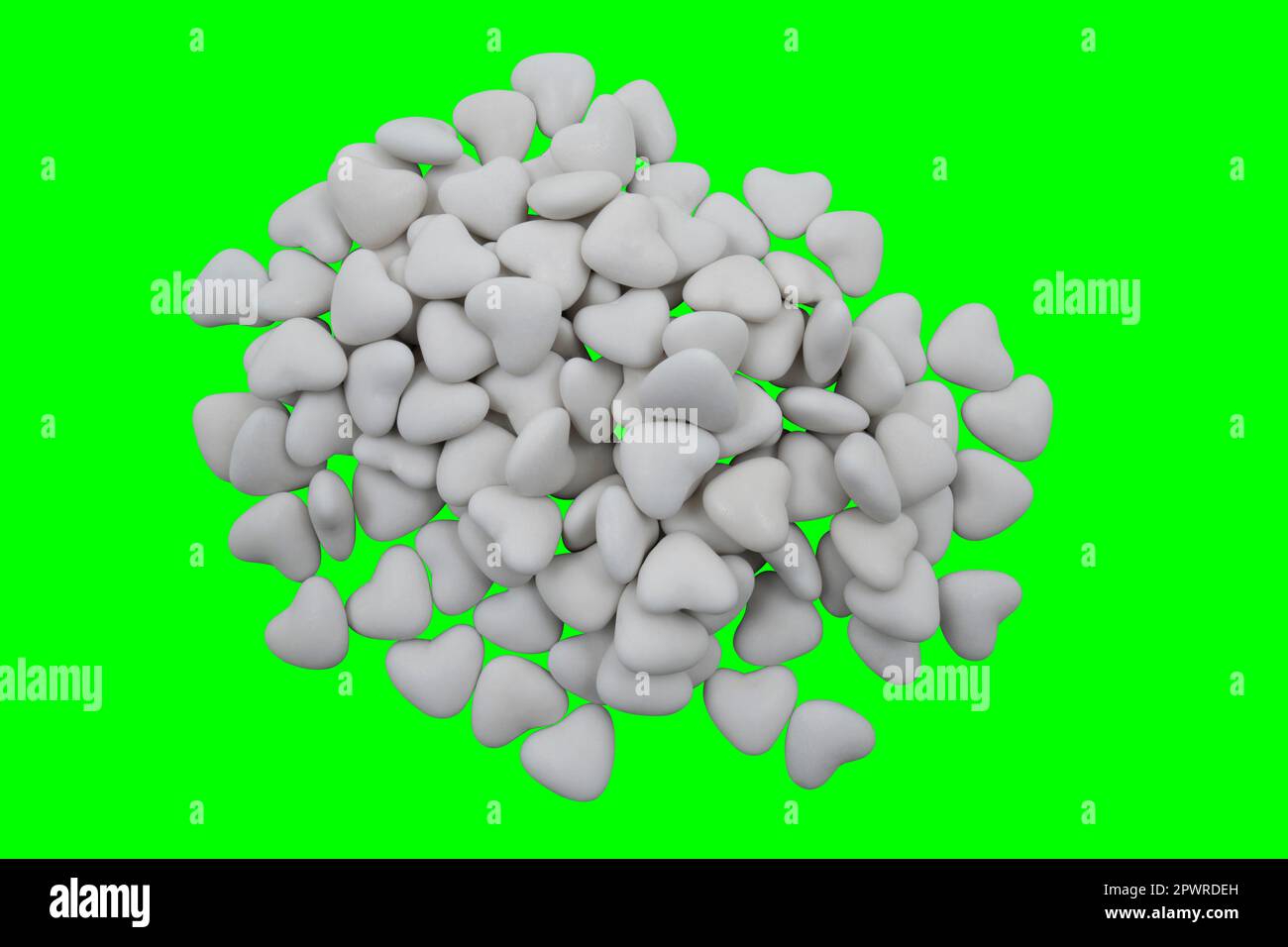 Ein Haufen weißer herzförmiger Süßigkeiten (Nahaufnahme) auf grünem Hintergrund (Chroma-Schlüssel). Blick von oben Stockfoto