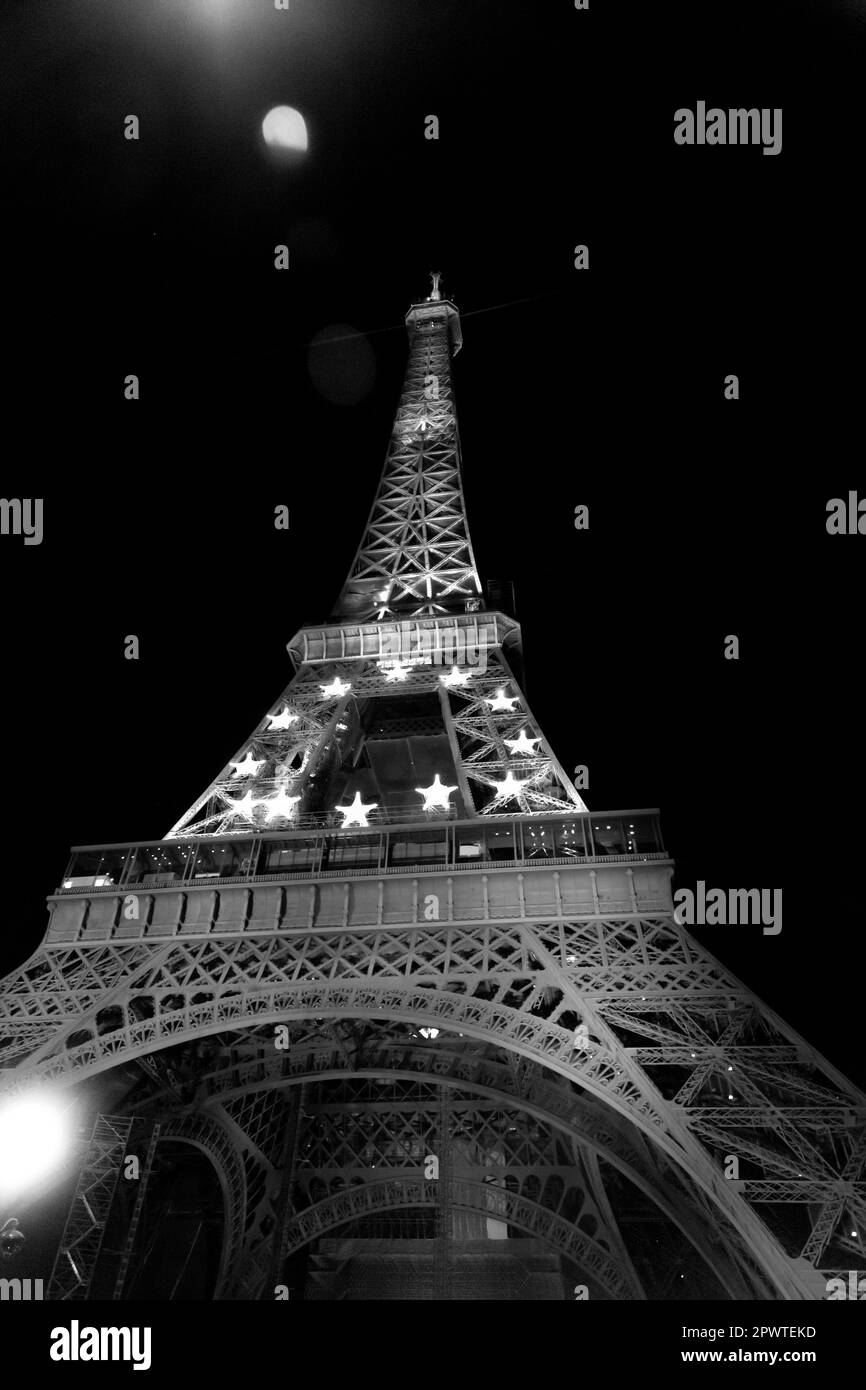 Der berühmte Eiffelturm, der nachts beleuchtet wird, der schmiedeeiserne Gitterturm auf dem Champ de Mars in Paris, Frankreich. Stockfoto