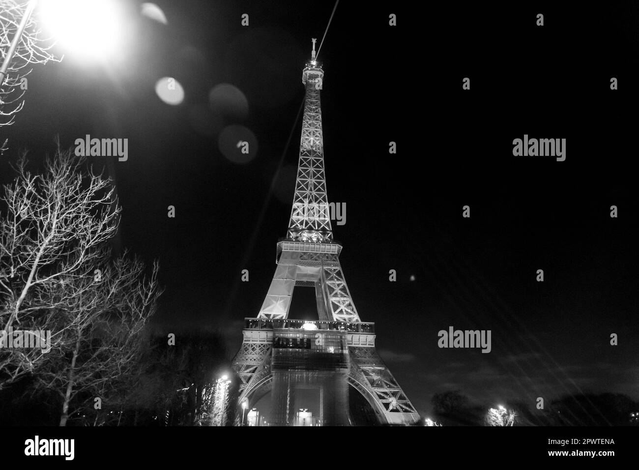 Der berühmte Eiffelturm, der nachts beleuchtet wird, der schmiedeeiserne Gitterturm auf dem Champ de Mars in Paris, Frankreich. Stockfoto