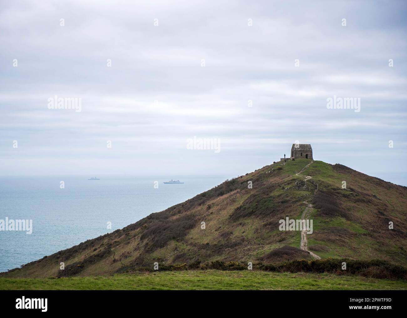 Rame Head, mittelalterliche Kapelle mit Booten in der Ferne, Cornwall, England, Großbritannien Stockfoto