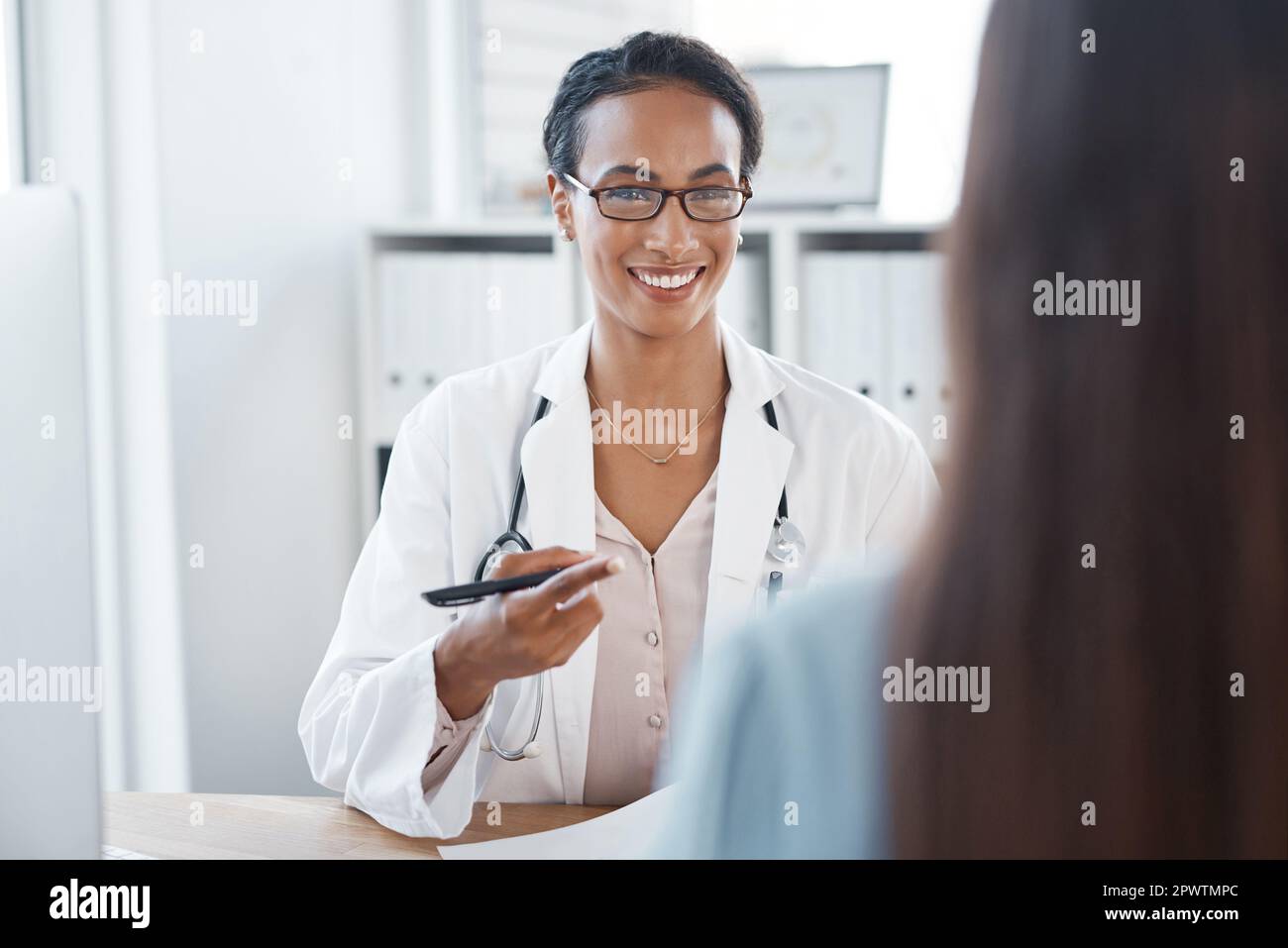 Ich habe tolle Neuigkeiten für dich. Eine junge Ärztin, die mit ihrer Patientin spricht Stockfoto