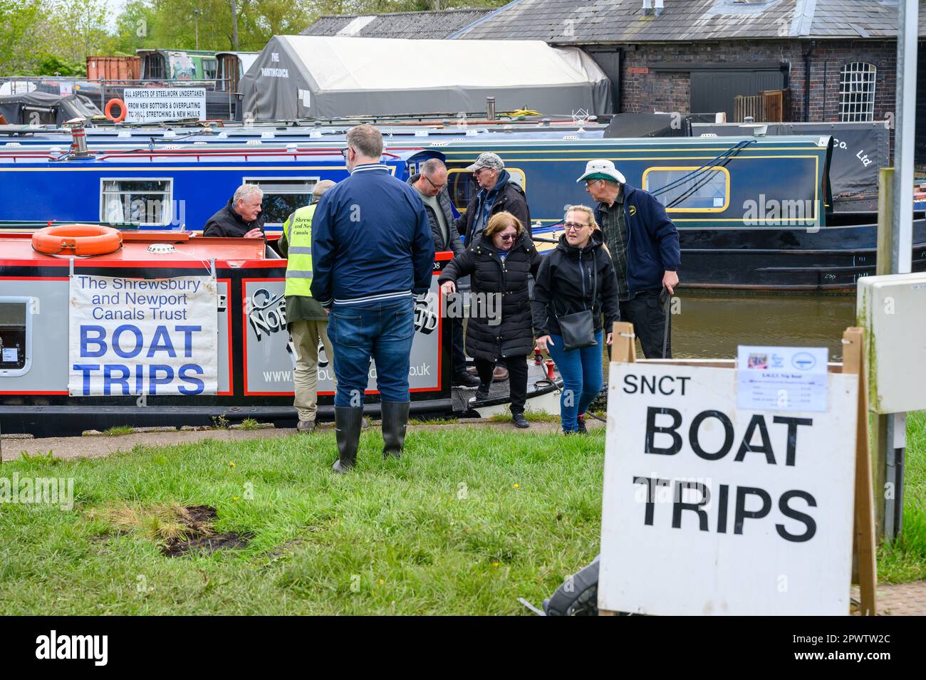 Besucher, die während eines Kanalfestivals auf dem Shropshire Union Canal an der Norbury Junction in Staffordshire von einem Ausflugsboot aussteigen. Stockfoto