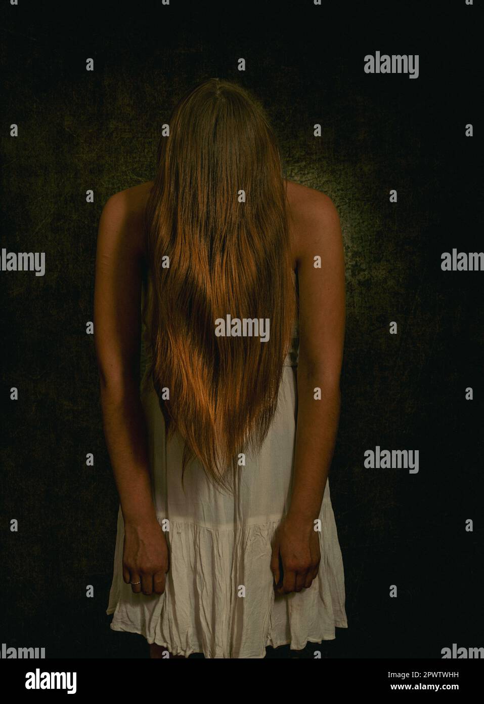 Frau mit psychischen Störungen, begriffliches Bild eines hinter ihren Haaren versteckten Mädchens, Depressionen oder geringes Selbstwertgefühl. Stockfoto