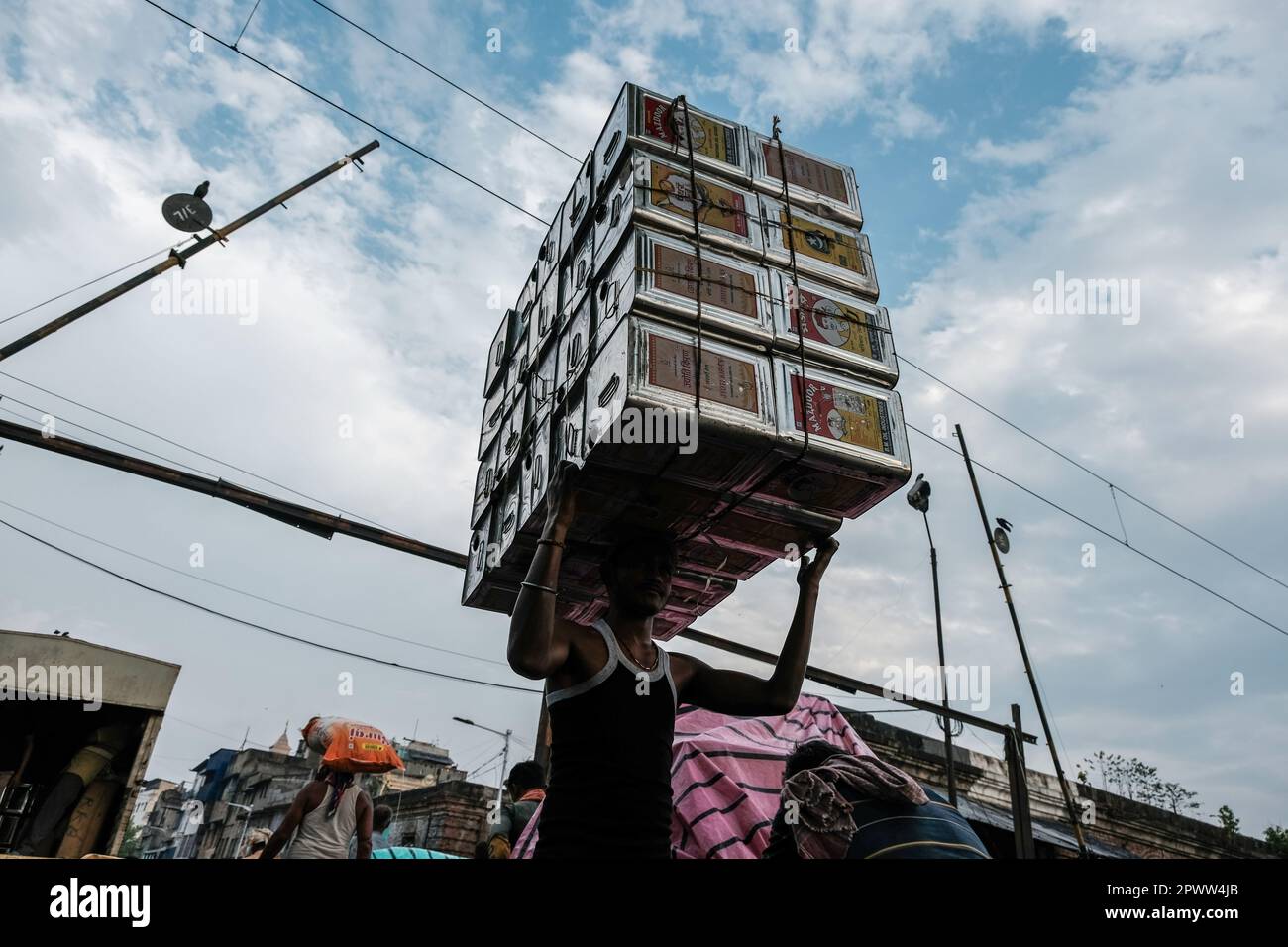 Kalkutta, Indien. 21. März 2023. Ein Arbeiter wurde mit Ölbehältern im Barabazar-Marktgebiet von Nord-Kalkutta gesehen. Der Internationale Tag der Arbeit, auch bekannt als „Mai-Tag“ oder „Internationaler Tag der Arbeitnehmer“, wird jedes Jahr am 01. Mai gefeiert, um den Beitrag der Arbeitnehmer zur Gesellschaft zu würdigen. Kredit: SOPA Images Limited/Alamy Live News Stockfoto