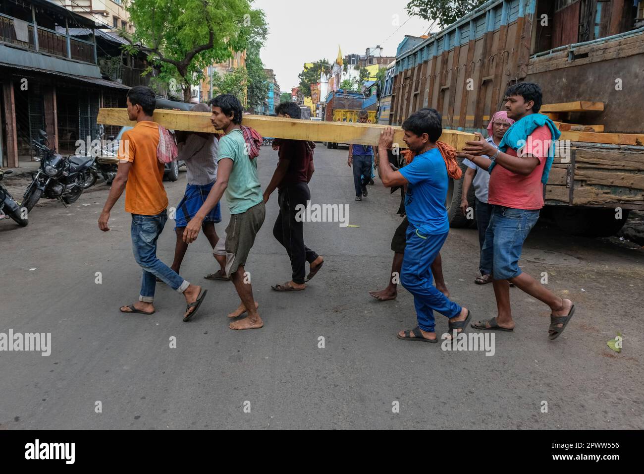 Kalkutta, Indien. 21. März 2023. Arbeiter wurden mit einem Holzstamm im Barabazar-Marktgebiet in Nord-Kalkutta gesehen. Der Internationale Tag der Arbeit, auch bekannt als „Mai-Tag“ oder „Internationaler Tag der Arbeitnehmer“, wird jedes Jahr am 01. Mai gefeiert, um den Beitrag der Arbeitnehmer zur Gesellschaft zu würdigen. (Foto: Dipayan Bose/SOPA Images/Sipa USA) Guthaben: SIPA USA/Alamy Live News Stockfoto