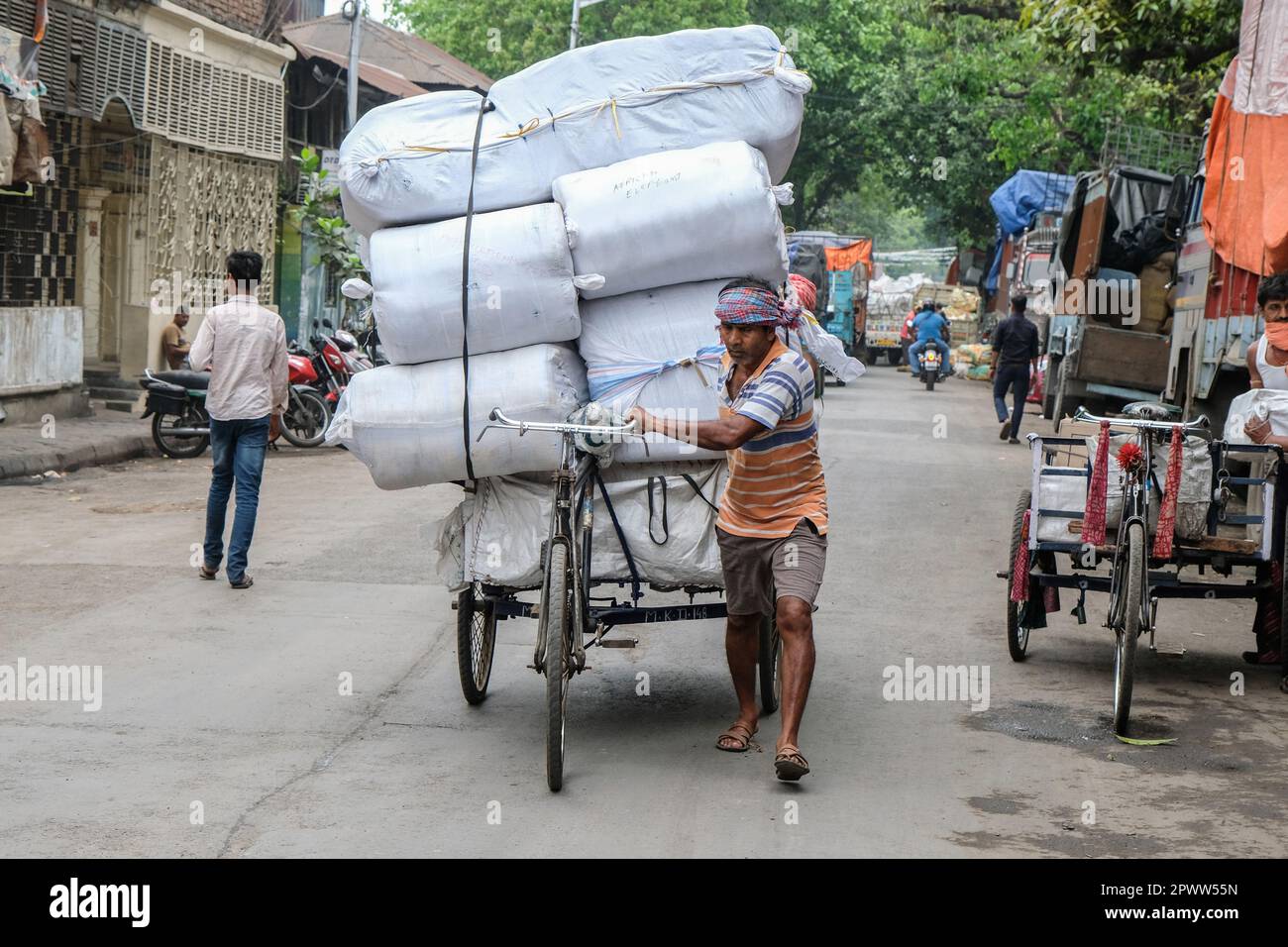 Kalkutta, Indien. 21. März 2023. Ein Arbeiter sah eine beladene Rikscha im Barabazar-Marktgebiet von Nord-Kalkutta schieben. Der Internationale Tag der Arbeit, auch bekannt als „Mai-Tag“ oder „Internationaler Tag der Arbeitnehmer“, wird jedes Jahr am 01. Mai gefeiert, um den Beitrag der Arbeitnehmer zur Gesellschaft zu würdigen. Kredit: SOPA Images Limited/Alamy Live News Stockfoto