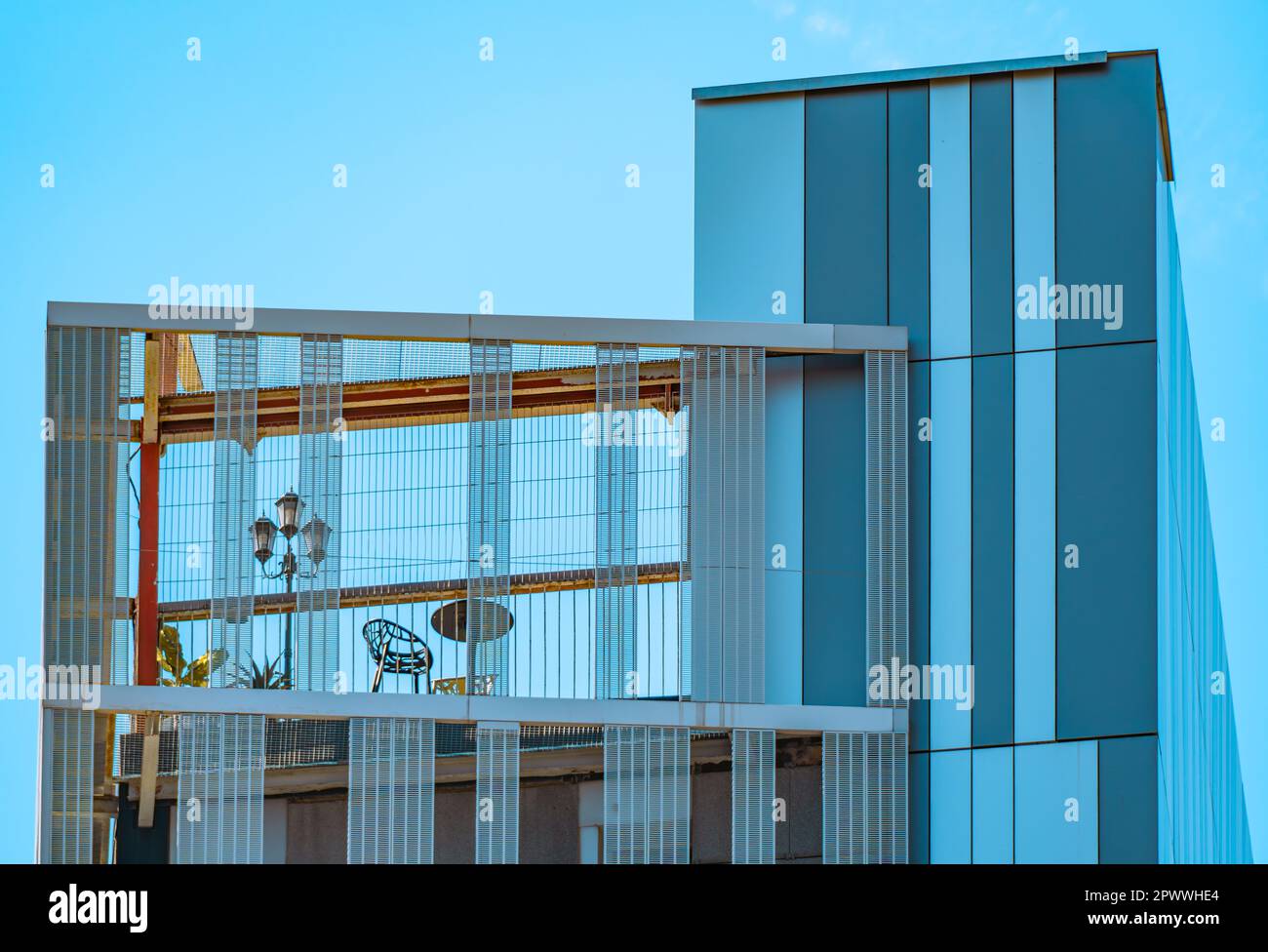 Details der Fassade und Struktur eines modernen, avantgardistischen und minimalistischen Gebäudes mit großen rechteckigen blauen Kristallen und einer Terrasse im Stockfoto