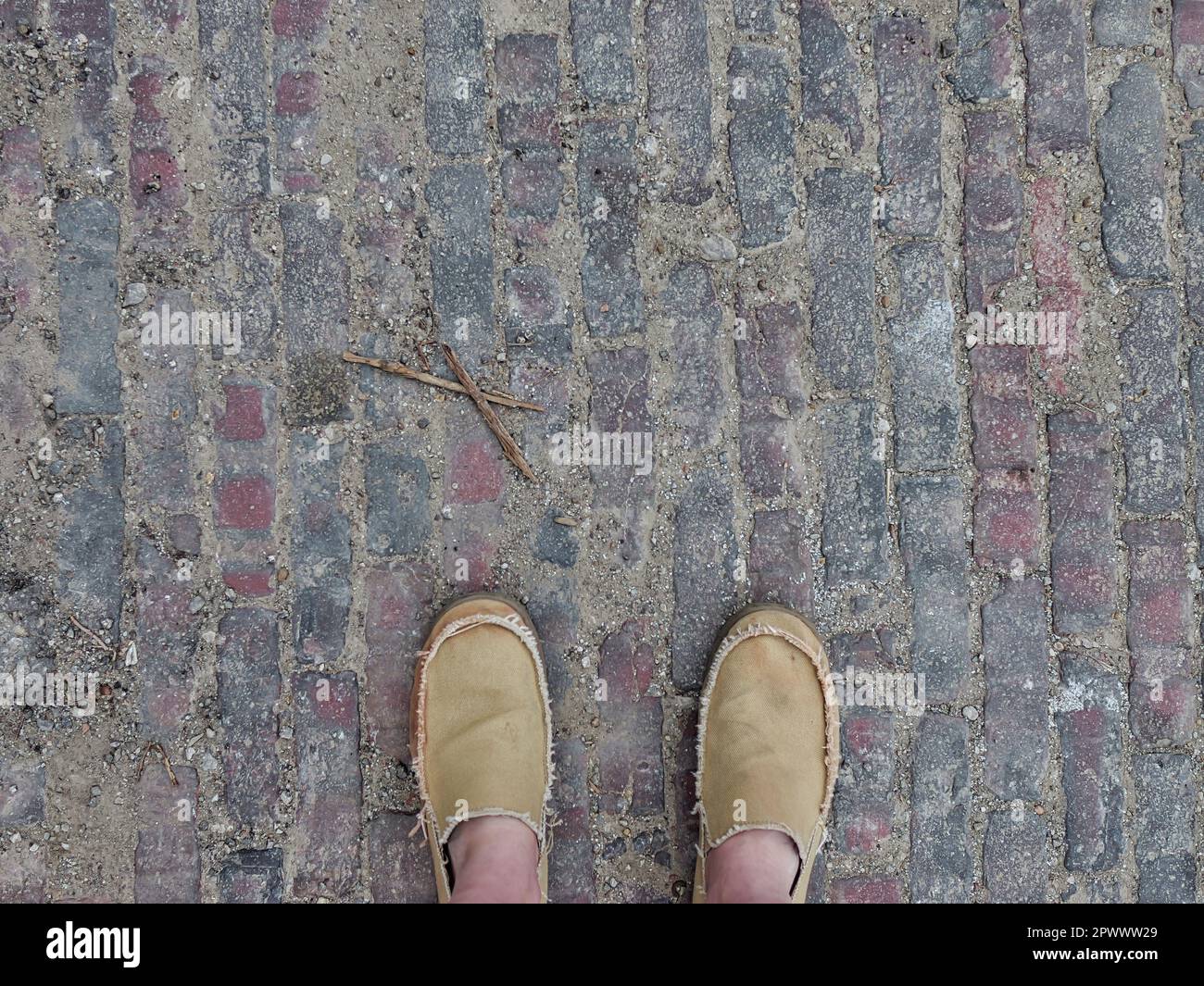 Mann steht auf Old Rustic Brick Road Textur – Füge Text für deine Designs hinzu Stockfoto
