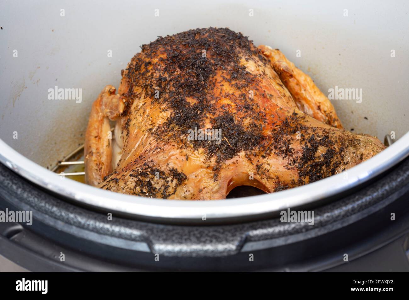 Hähnchen mit Kräutermischungen, in einer Airfryer gekocht. Gesundes, kostengünstiges Kochkonzept Stockfoto