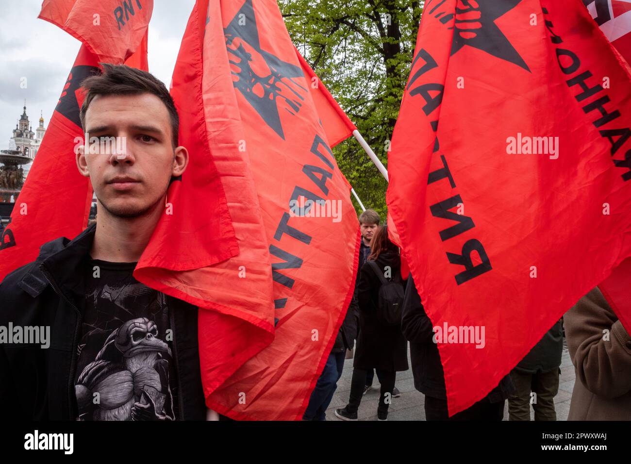 Moskau, Russland. 1. Mai 2023. Ein junger Mann hält die rote Flagge der Revolutionären Arbeiterpartei, während sich andere anlässlich des Labor Day, auch bekannt als May Day, am Denkmal des deutschen Philosophen Karl Marx aus dem 19. Jahrhundert in der Nähe des Roten Platzes in Moskau, Russland, versammeln. Nikolay Vinokurov/Alamy Live News Stockfoto