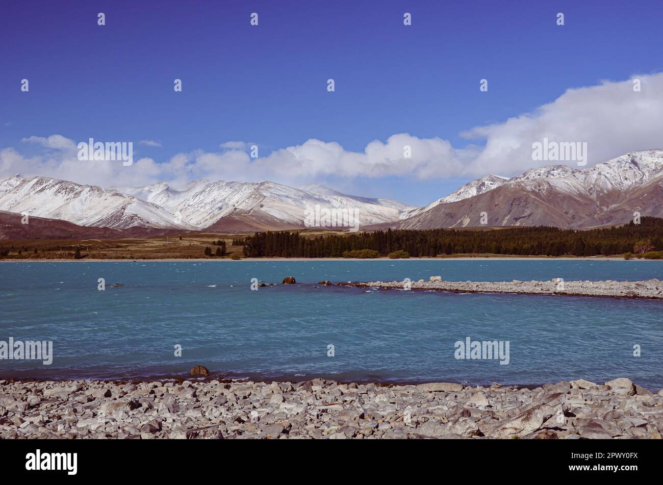 Der Lake Tekapo wird von schneebedeckten Berggipfeln in Neuseeland eingerahmt Stockfoto