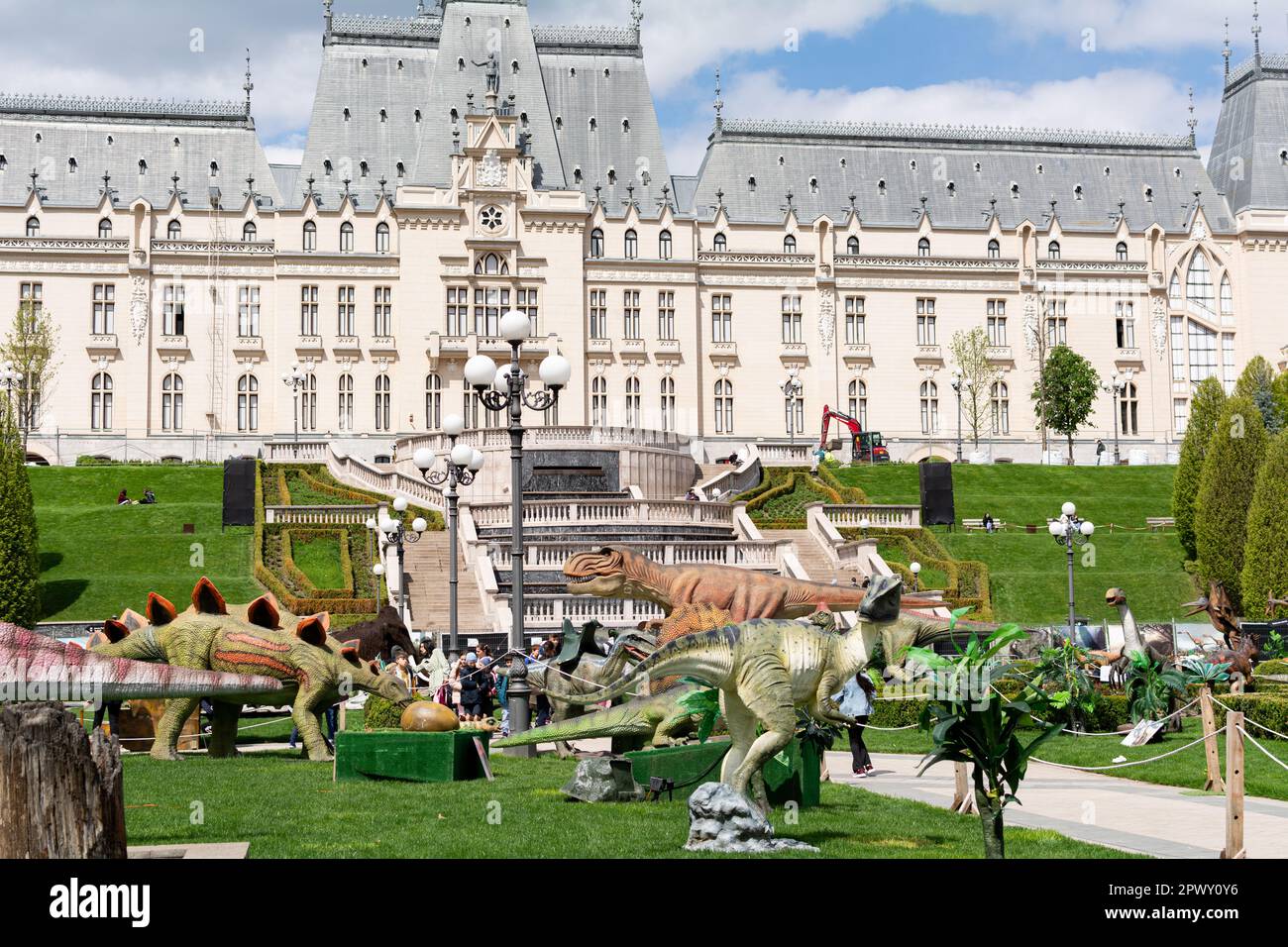 Iasi, Rumänien - 28. April 2023: Dinosaurierpark im Palas Public Garden. Palatul Culturii oder Kulturpalast im Hintergrund Stockfoto