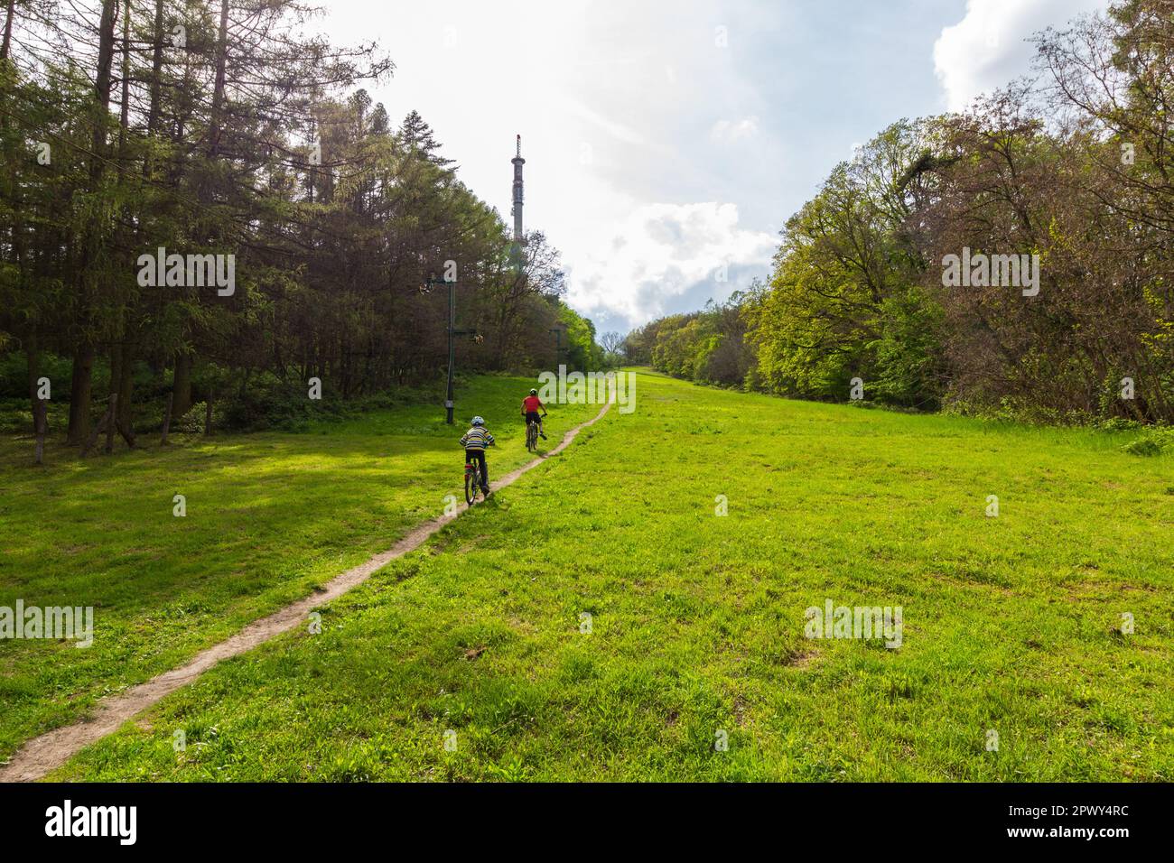 Zwei Radfahrer fahren auf der ehemaligen Skipiste bergauf zum Fernsehturm in Dalos-hegy, Sopron, Ungarn Stockfoto