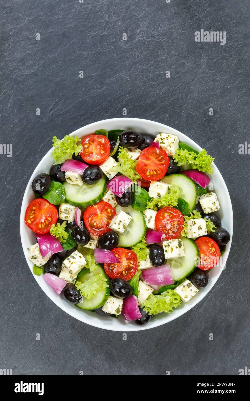 Griechischer Salat mit frischen Tomaten, Oliven und Fetakäse gesundes Essen aus dem Hochformat mit Kopierraum auf einem Schiefergericht Stockfoto