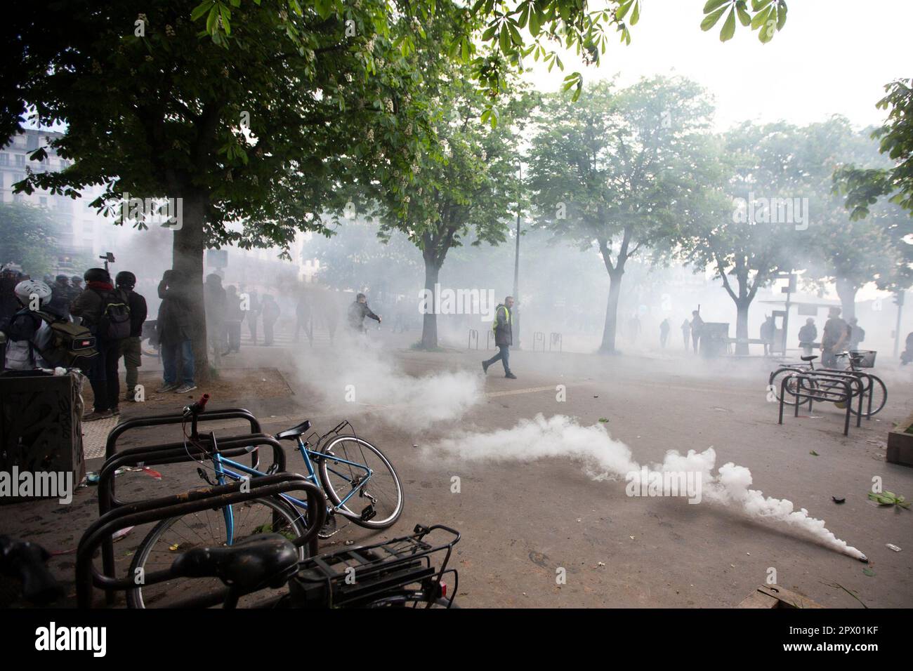 Demonstranten und französische Polizei treffen während der Bürgerkriegsaufstände am 1. Mai 2023 im Zentrum von Paris aufeinander. Viele kamen zu Wort, um ihre Abneigung gegen Präsident Macron und seine derzeitige Politik zum Ausdruck zu bringen. Bild des Austritts von Tränengas aus dem Kanister. Stockfoto