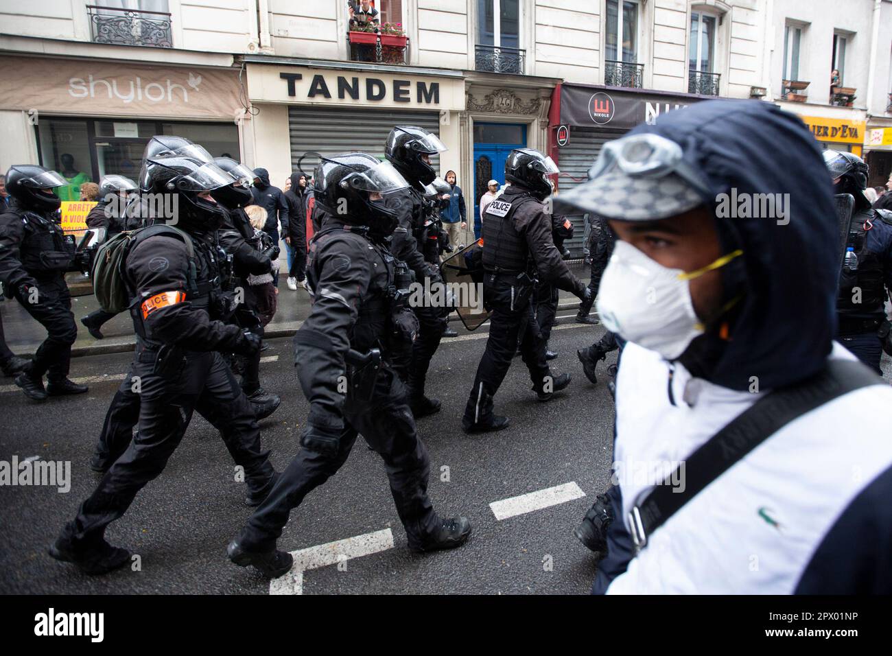 Demonstranten und französische Polizei treffen während der Bürgerkriegsaufstände am 1. Mai 2023 im Zentrum von Paris aufeinander. Viele kamen zu Wort, um ihre Abneigung gegen Präsident Macron und seine derzeitige Politik zum Ausdruck zu bringen. Auf dem Bild ist ein Demonstrant zu sehen, der an einer Gruppe französischer Polizei vorbeiläuft, während sie im Einsatz sind. Stockfoto