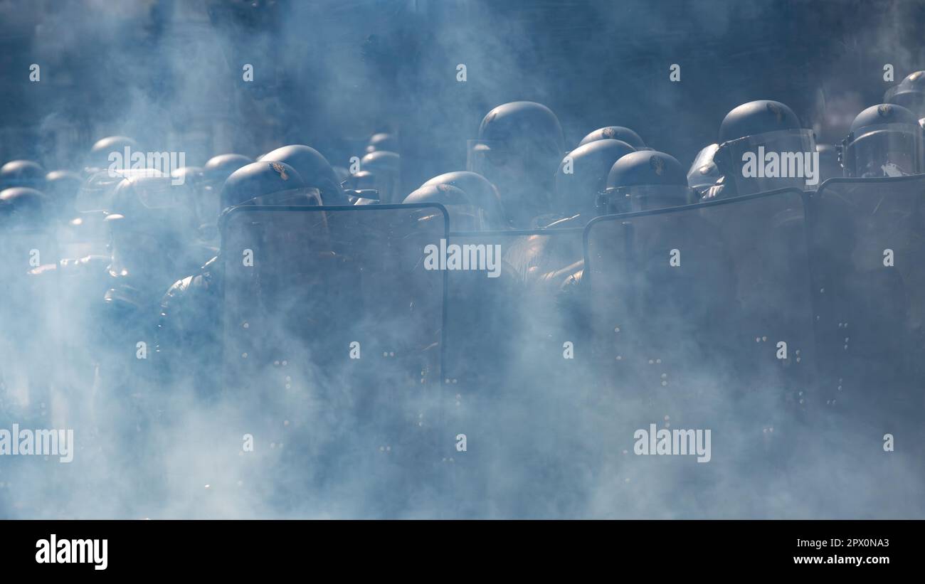 Französische Gendarmen in Aufruhr-Ausrüstung standen während eines Protests gegen die Rentenreform in einem schweren Nebel aus Tränengas auf dem Place de la Nation, Paris, Frankreich Stockfoto
