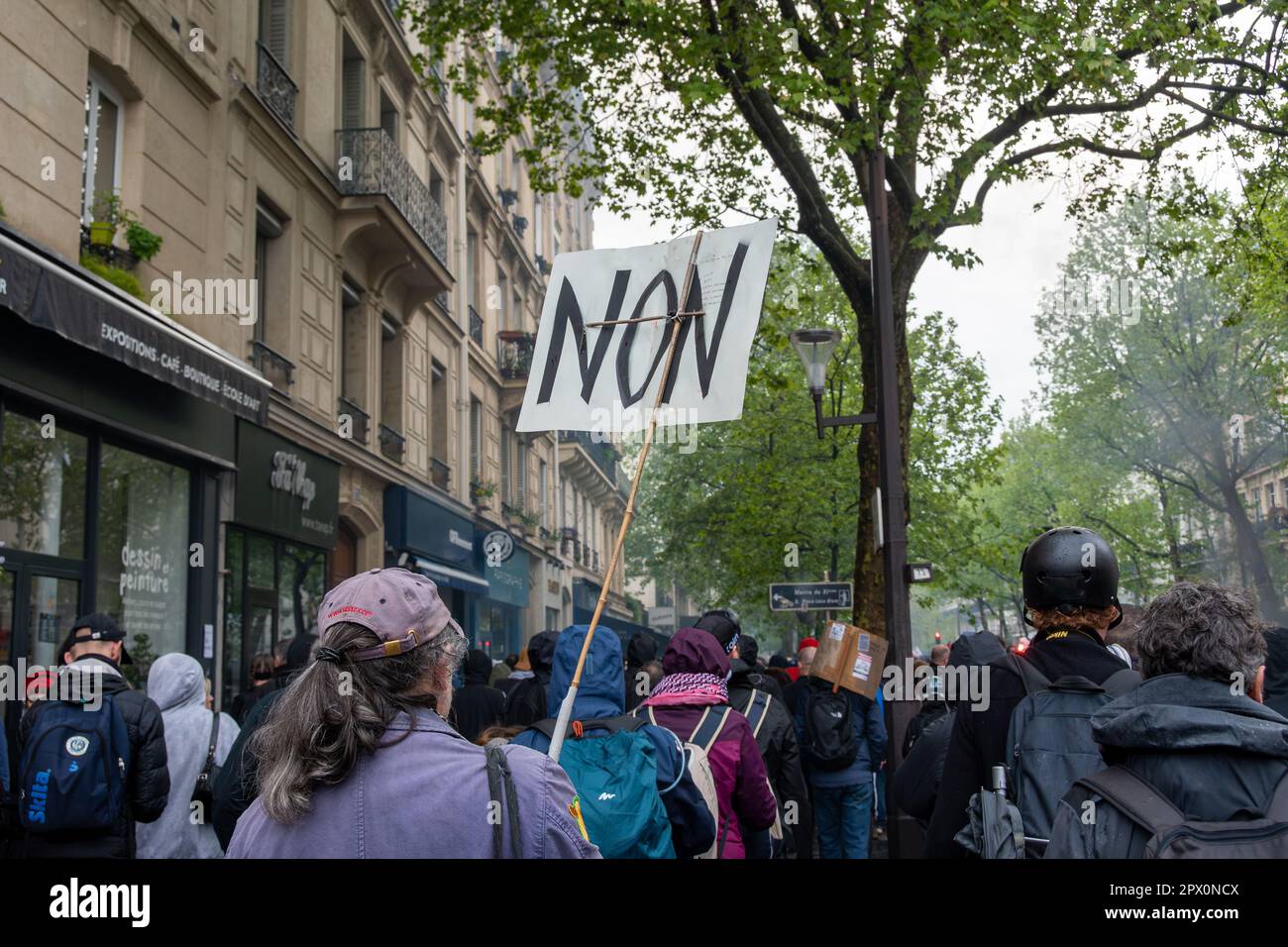 Weibliche Demonstrantin mit einem Schild mit dem französischen Wort "Non" während einer Demonstration gegen die Rentenreform der französischen Regierung Stockfoto