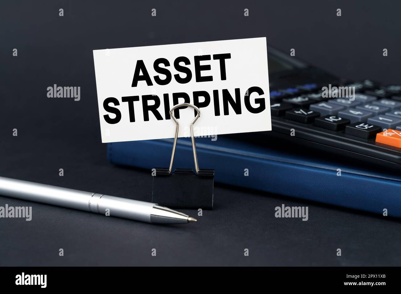 Geschäftskonzept. Auf dem Tisch befinden sich ein Notizbuch, ein Taschenrechner, ein Stift und eine Visitenkarte mit der Aufschrift „Asset Stripping“ Stockfoto