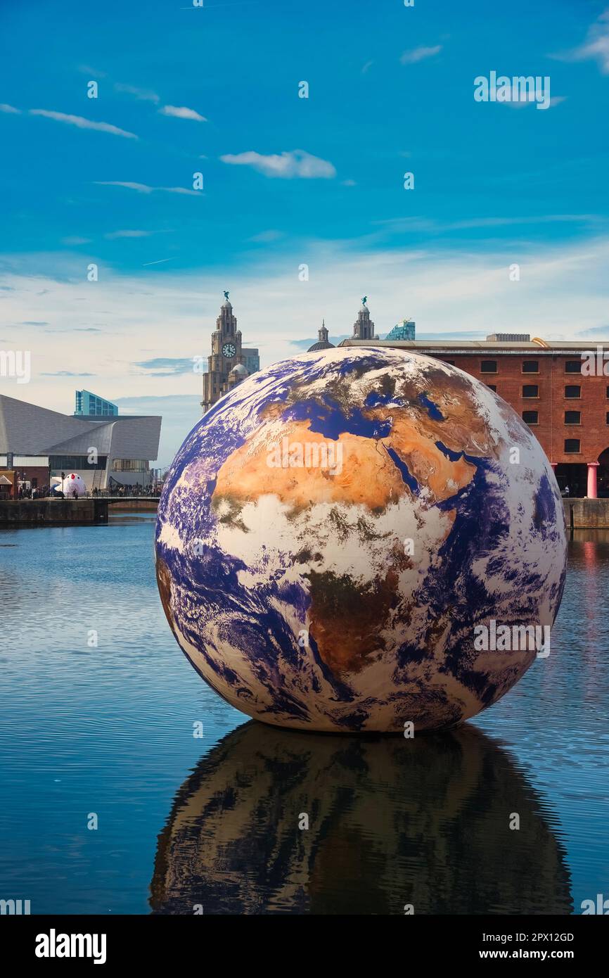 Liverpool, Großbritannien. 29. April 2023. Eine riesige Kunstinstallation mit einem Durchmesser von 10m mm Floating Earth vom Künstler Luke Jerram im Royal Albert Dock Liverpool mit dem berühmten Liver Building im Hintergrund. Kredit: SOPA Images Limited/Alamy Live News Stockfoto