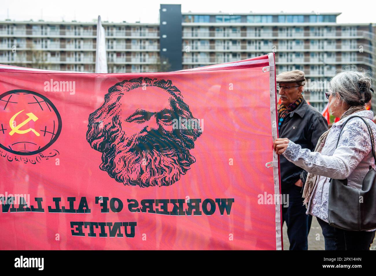 Man sieht eine Frau mit einem großen Banner, auf dem das Porträt von Karl Marx steht. Am Tag des Internationalen Arbeitertags, auch als Tag der Arbeit bekannt, marschierten die Menschen in Amsterdam, um faire Arbeitsbedingungen wie einen Mindestlohn von 14 Euro pro Stunde, unbefristete Verträge, guten sozialen Wohnraum, ein gutes Rentensystem, freien Zugang zu vollständiger (psychischer) Gesundheitsversorgung und kostenlose Bildung zu fordern. Tausende von Menschen nahmen die Straßen von Amsterdam ein. In den Niederlanden führt der Tag der Arbeit in der Regel nicht zu Störungen. (Foto: Ana Fernandez/SOPA Images/Sipa USA) Stockfoto