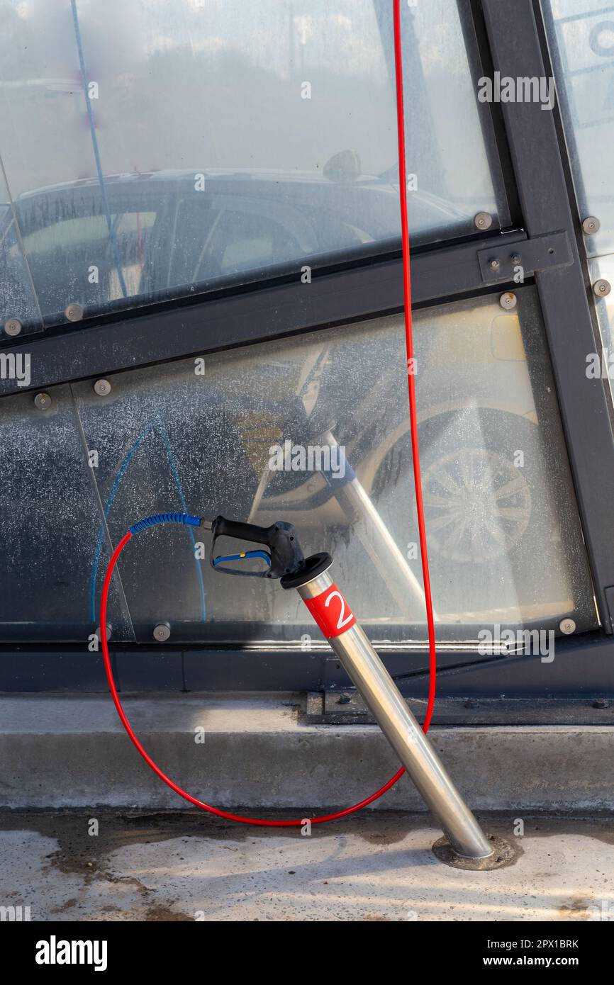 Eine Hochdruckwaschpistole in einem Halter in einer Autowaschanlage. Stockfoto