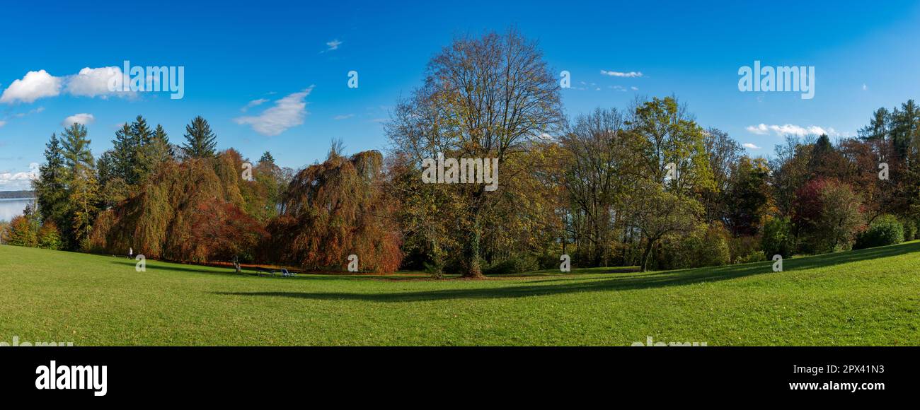 Panoramablick über eine herbstliche Landschaft mit Bäumen, Wiesen und verfärbten Blättern am Starnberger See Stockfoto