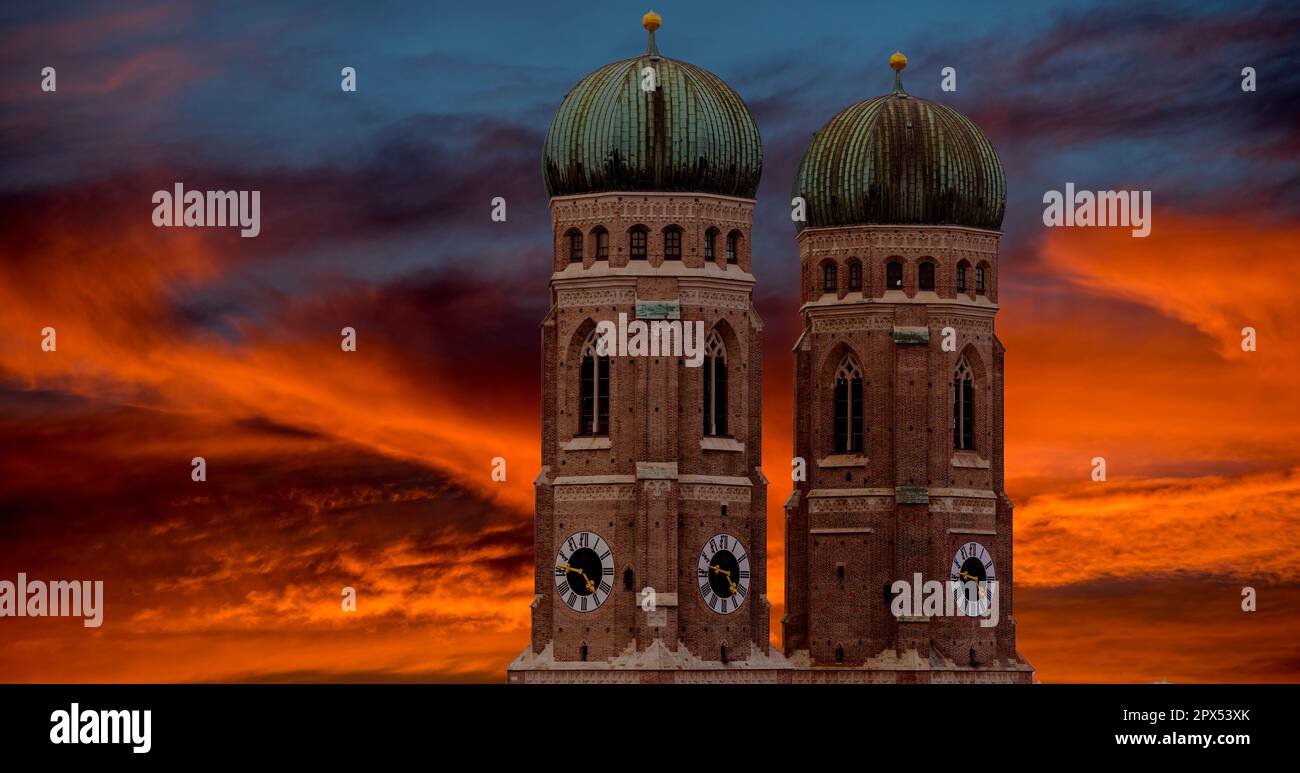 Die beiden Türme der Frauenkirche in der Münchner Altstadt vor dem dramatischen, farbenfrohen Abendhimmel mit heller bis mittlerer Wolkendecke Stockfoto