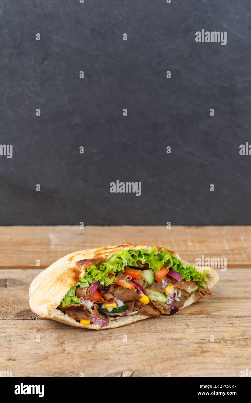 Döner Kebab Döner Kebap Fast Food in Fladenbrot auf Holzbrett-Hochformat mit Copyspace-Copy Space-Snack Stockfoto
