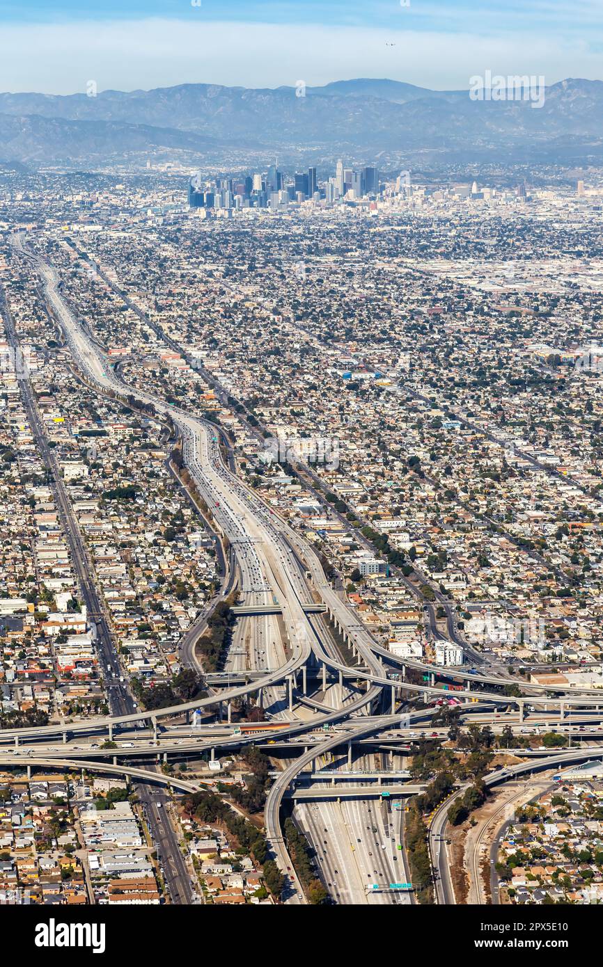 Luftaufnahme des Autobahnkreuzes Harbor und Century Freeway im Porträtformat mit der Innenstadt von Los Angeles, USA Stockfoto